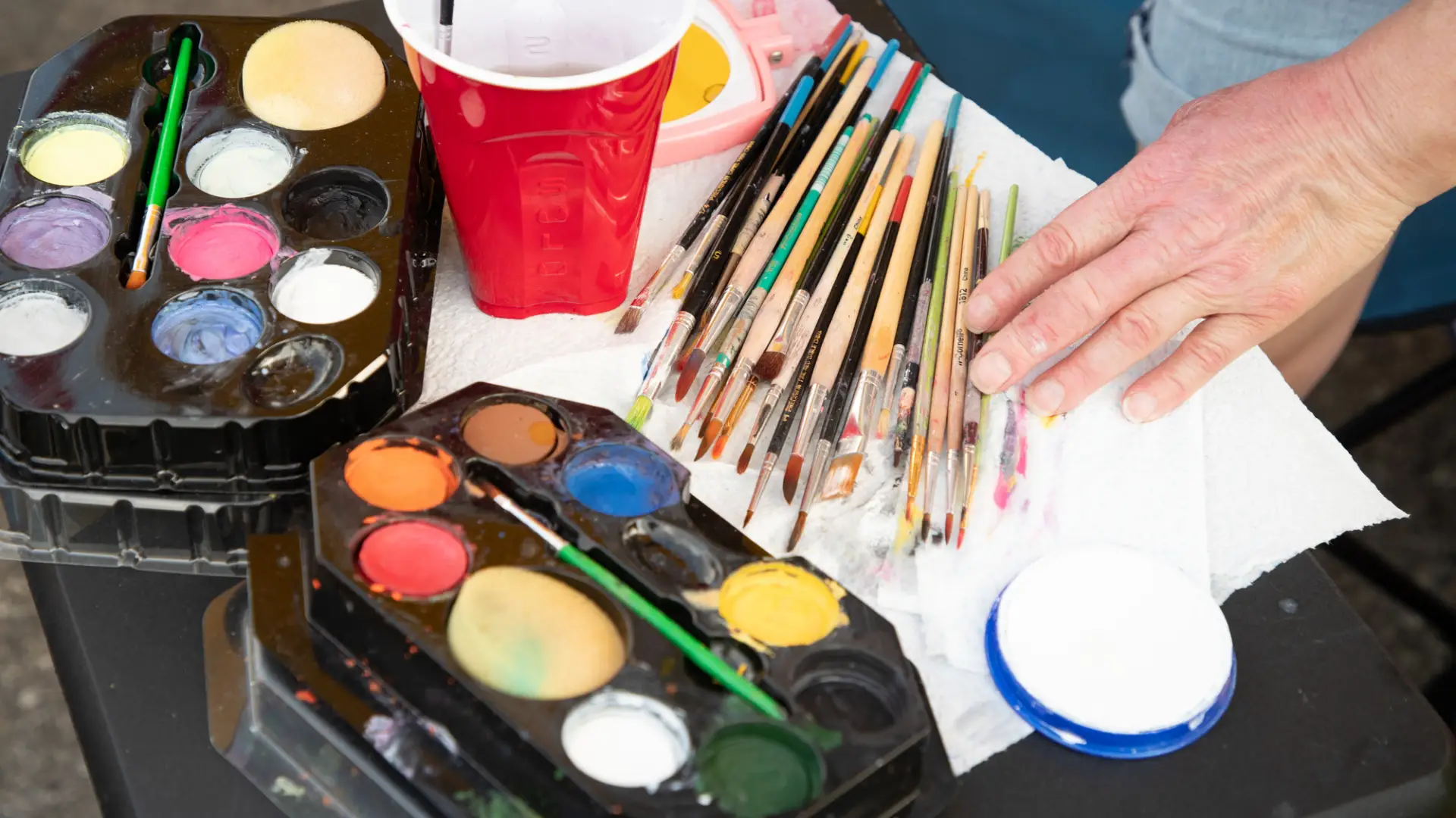 Colorful paints and brushes for an artist getting ready to work.