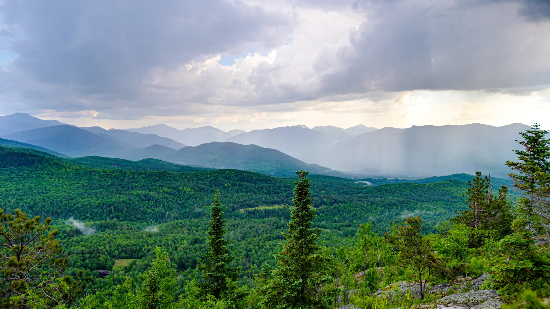 an aerial view of the green mountain range of Lake Placid in Summer.