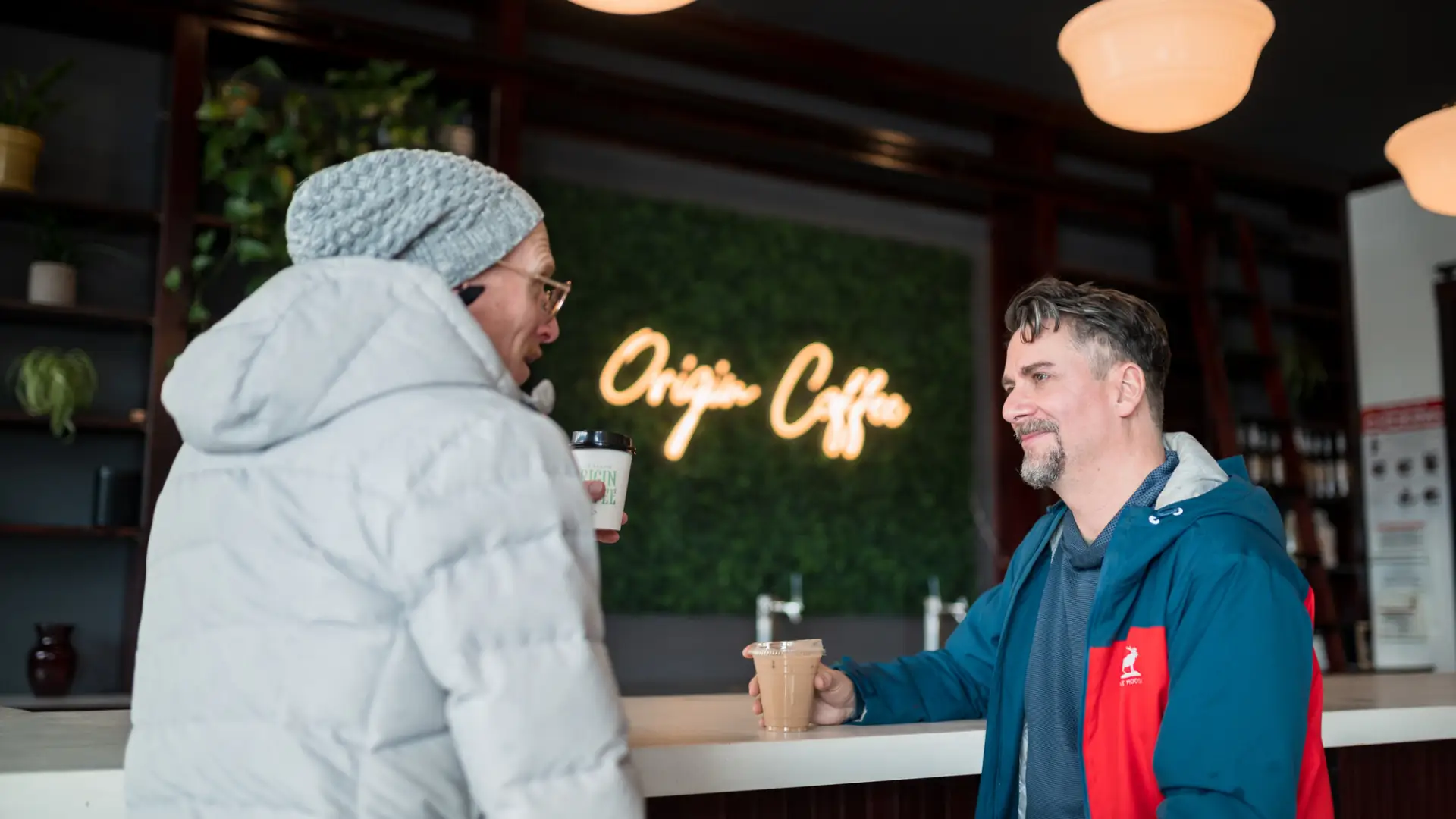 two men sit at a coffee bar at Origin Coffee