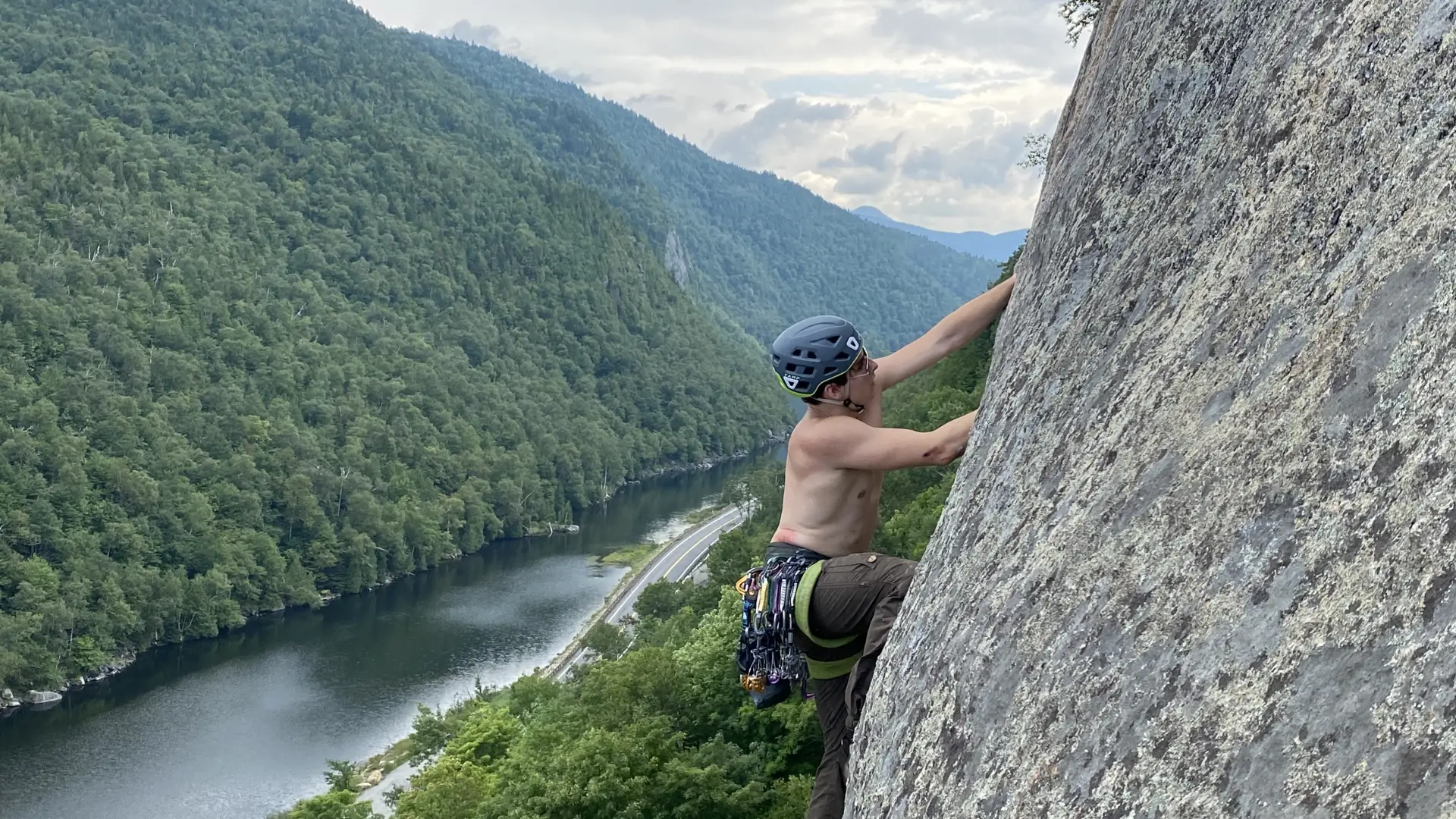 A person climbing above a scenic lake