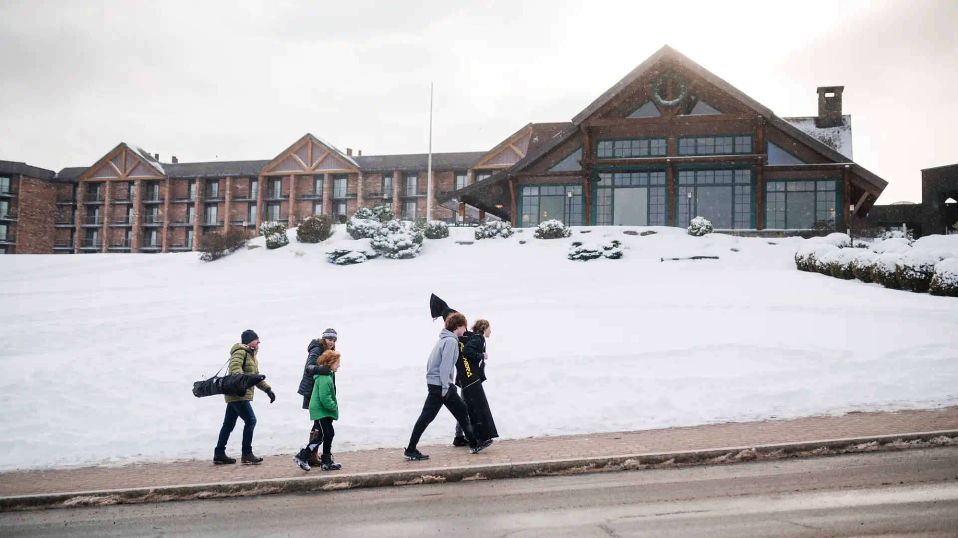 A family walking up a snowy sidewalk.