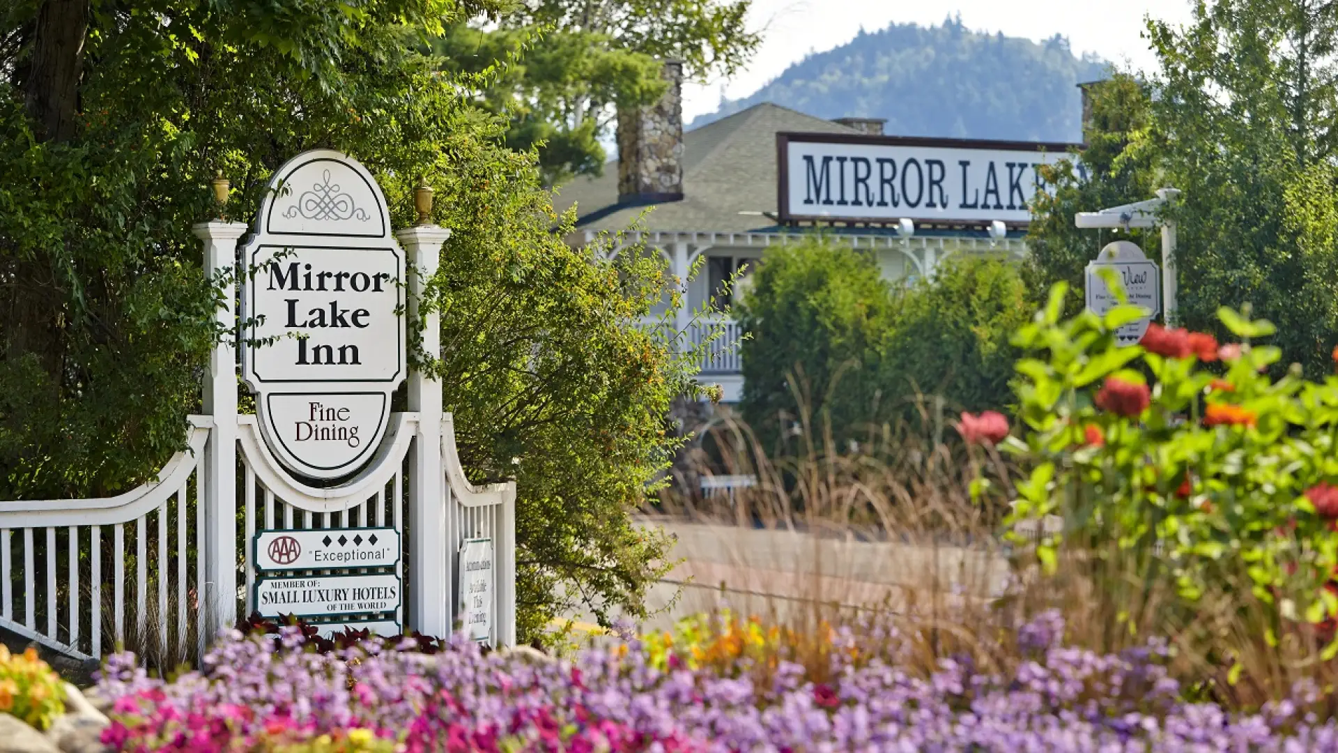 Image of the entry way with sign and glorious colorful summer flowers