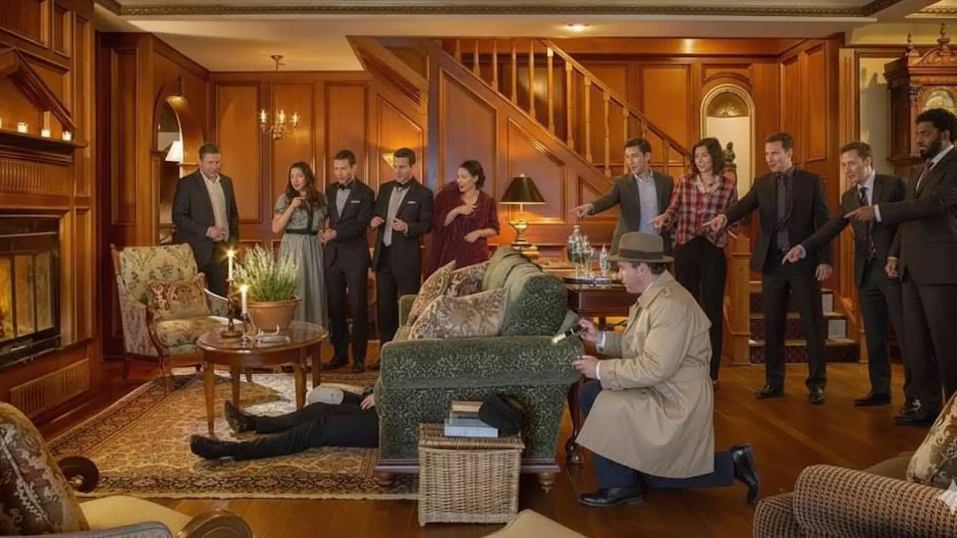 A variety of people in period dress stand in the dark wood paneled  entry way of the Mirror Lake Inn.