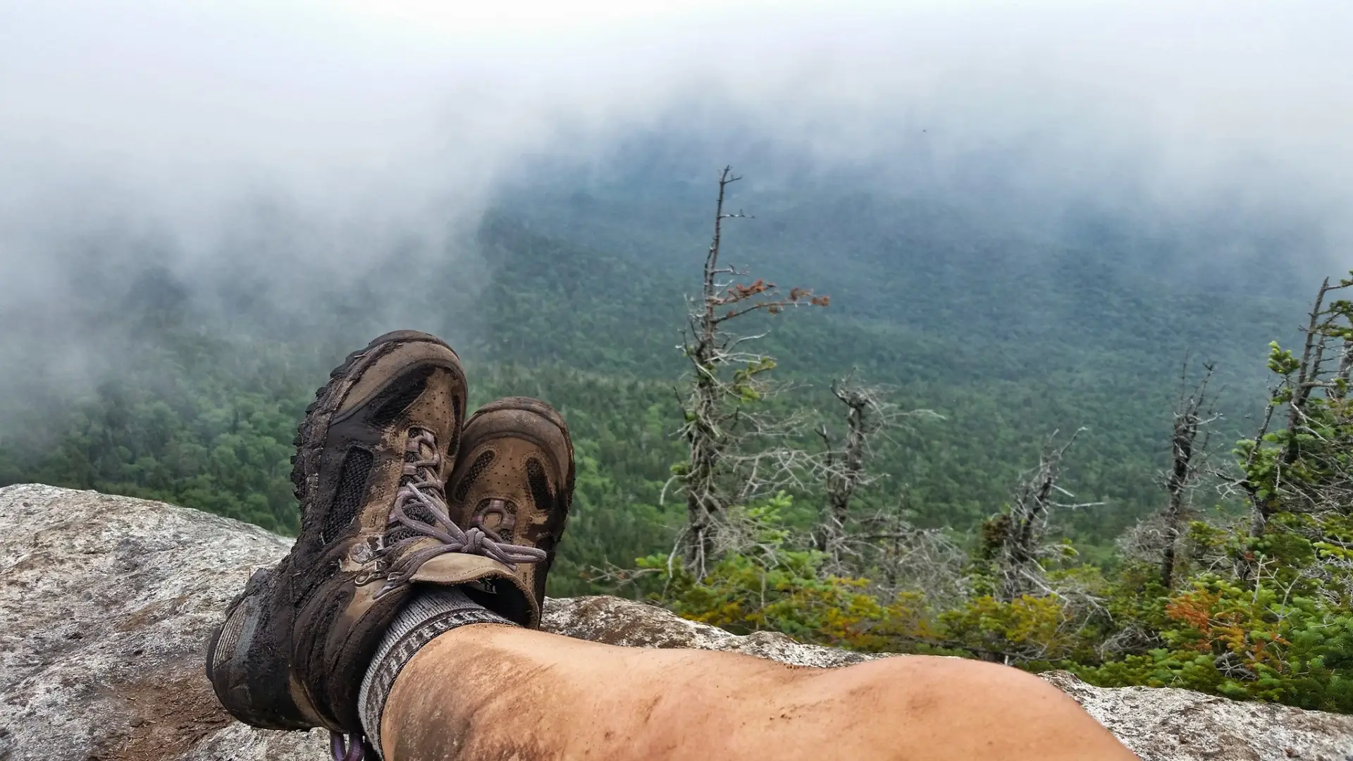 A hiker's legs and boots on a rocky outcropping