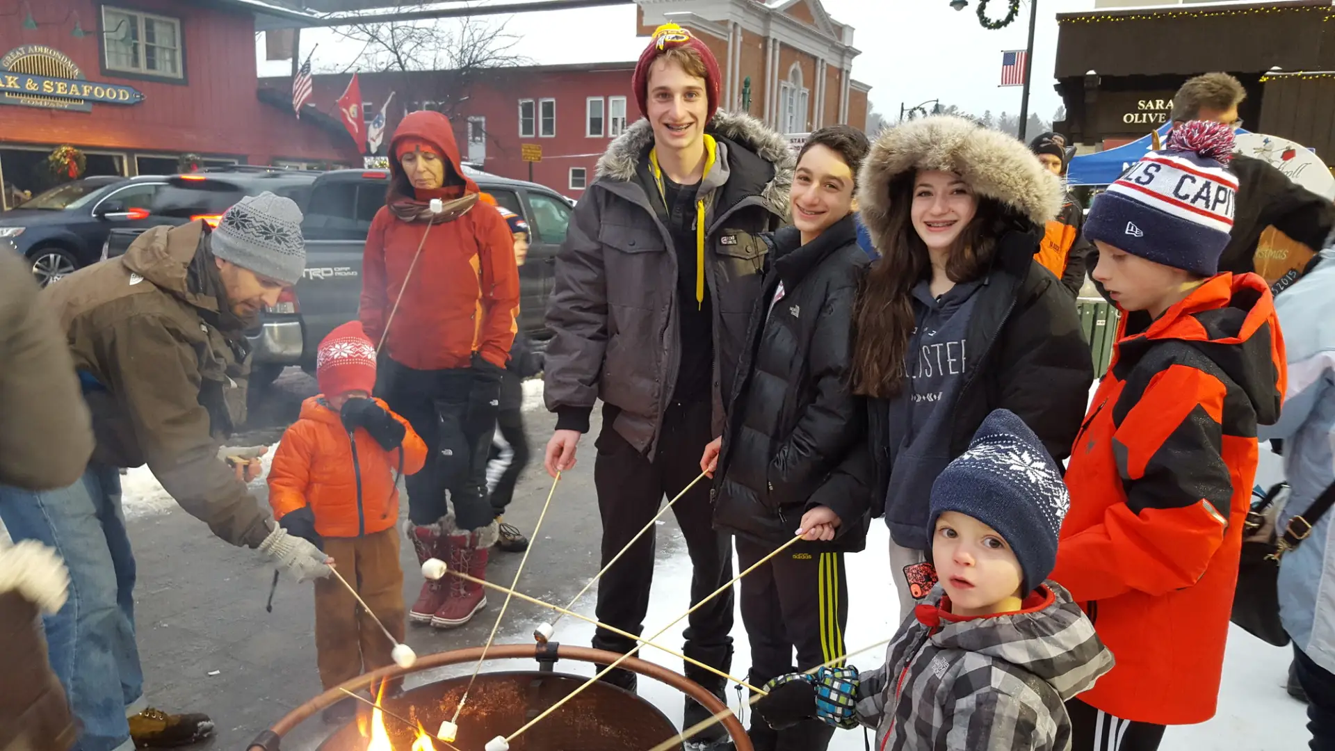 Group of young people roast marshmallows on Main Street.