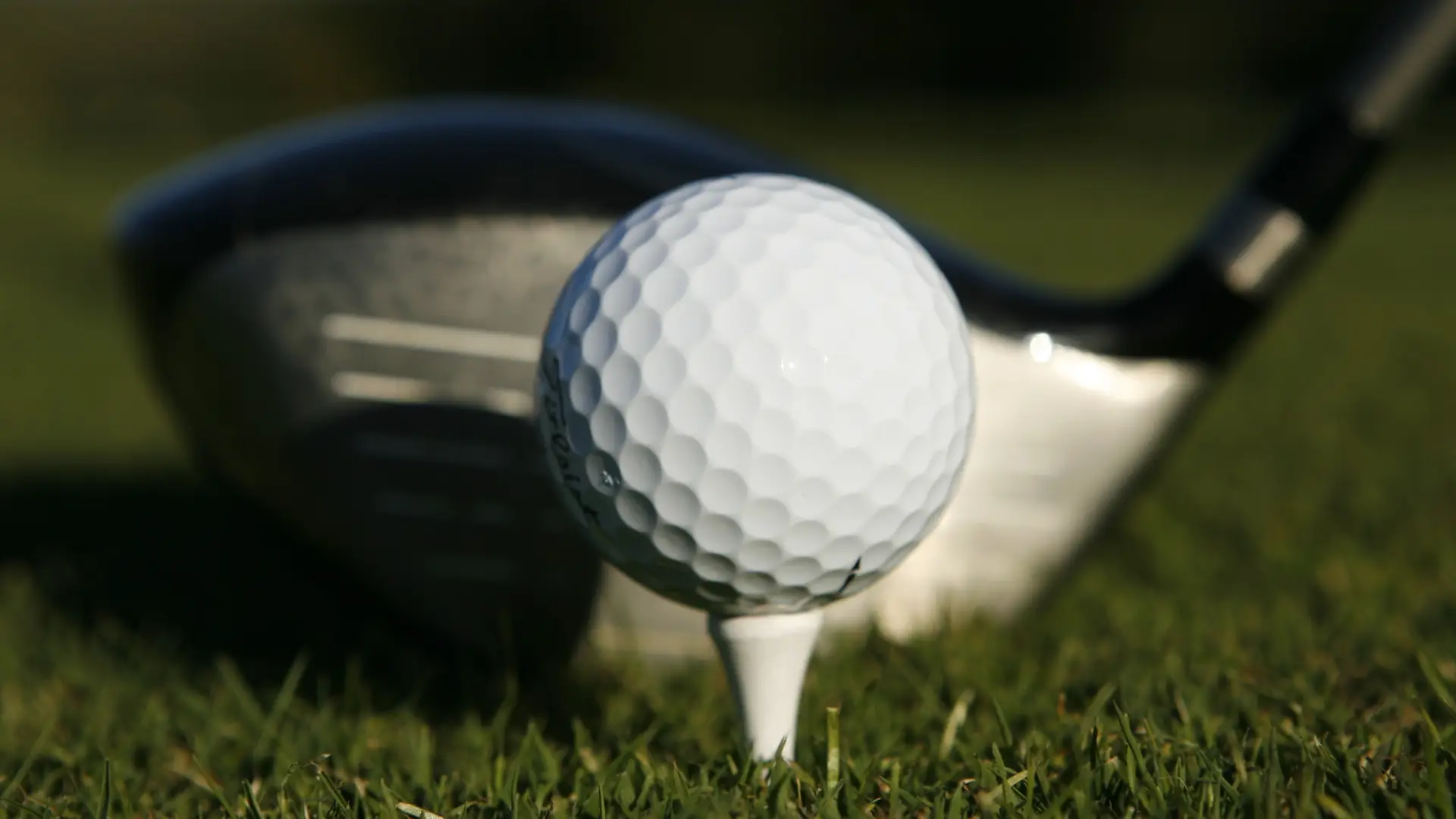 A close up of a person putting a golf ball.