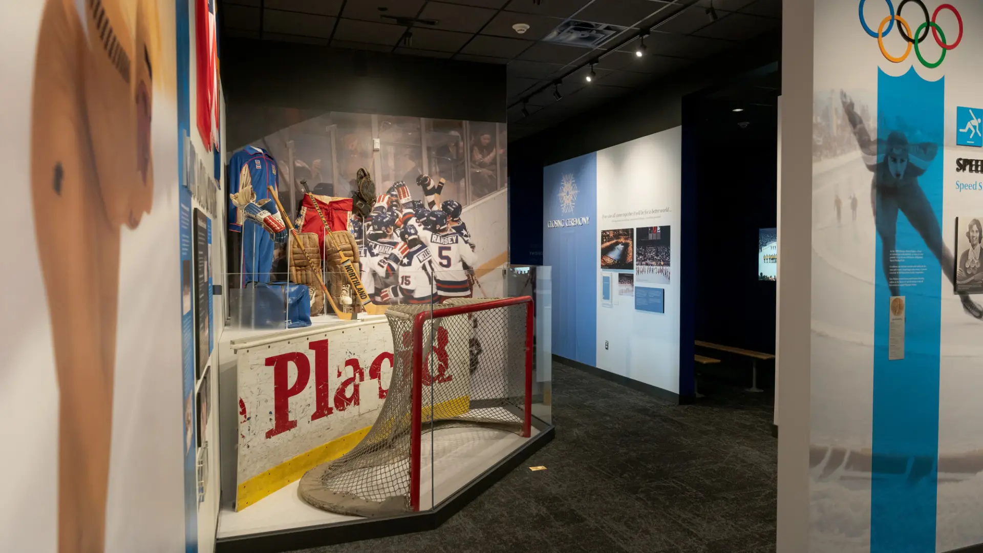 Interior view of Lake Placid Olympic History museum with several displays visible including a hockey goal