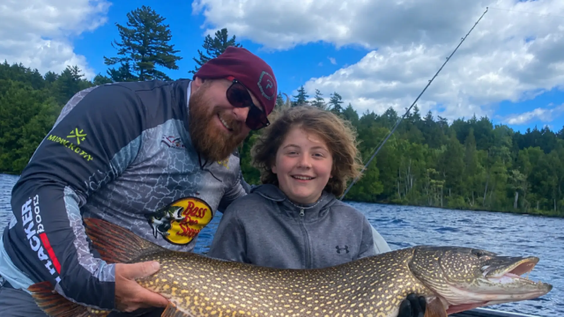 A man and a child hold a pike.