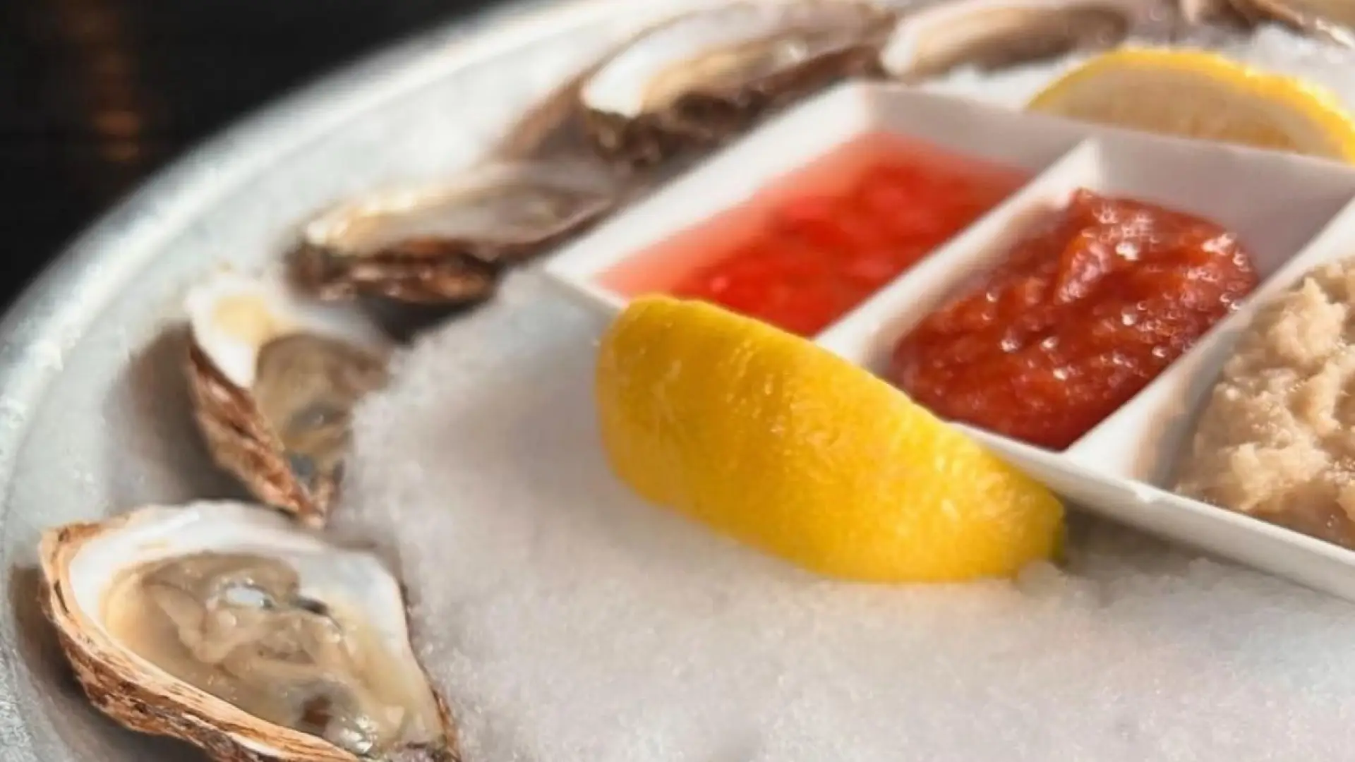 Oysters on a plate with lemon and sauces