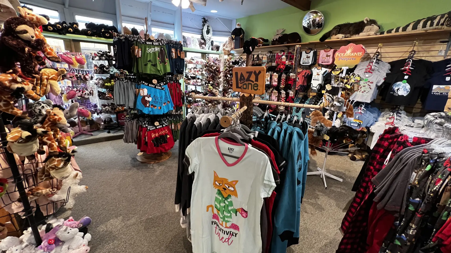 A brightly colored shop filled with racks of clothing and shelves of stuffed animals.