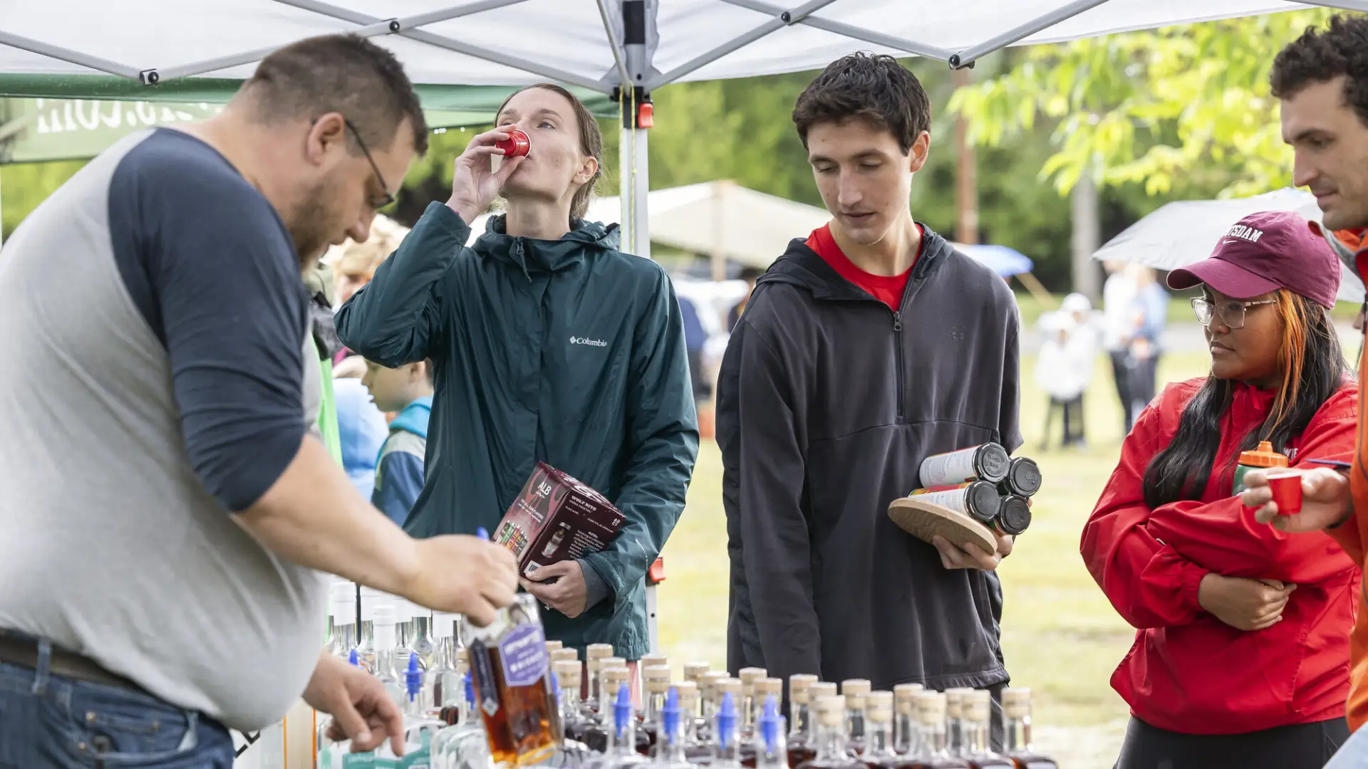 Guests sample whiskey as vendor pours