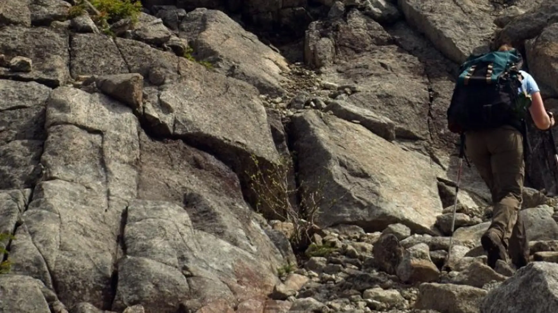 A hiker ascending a steep rocky trail