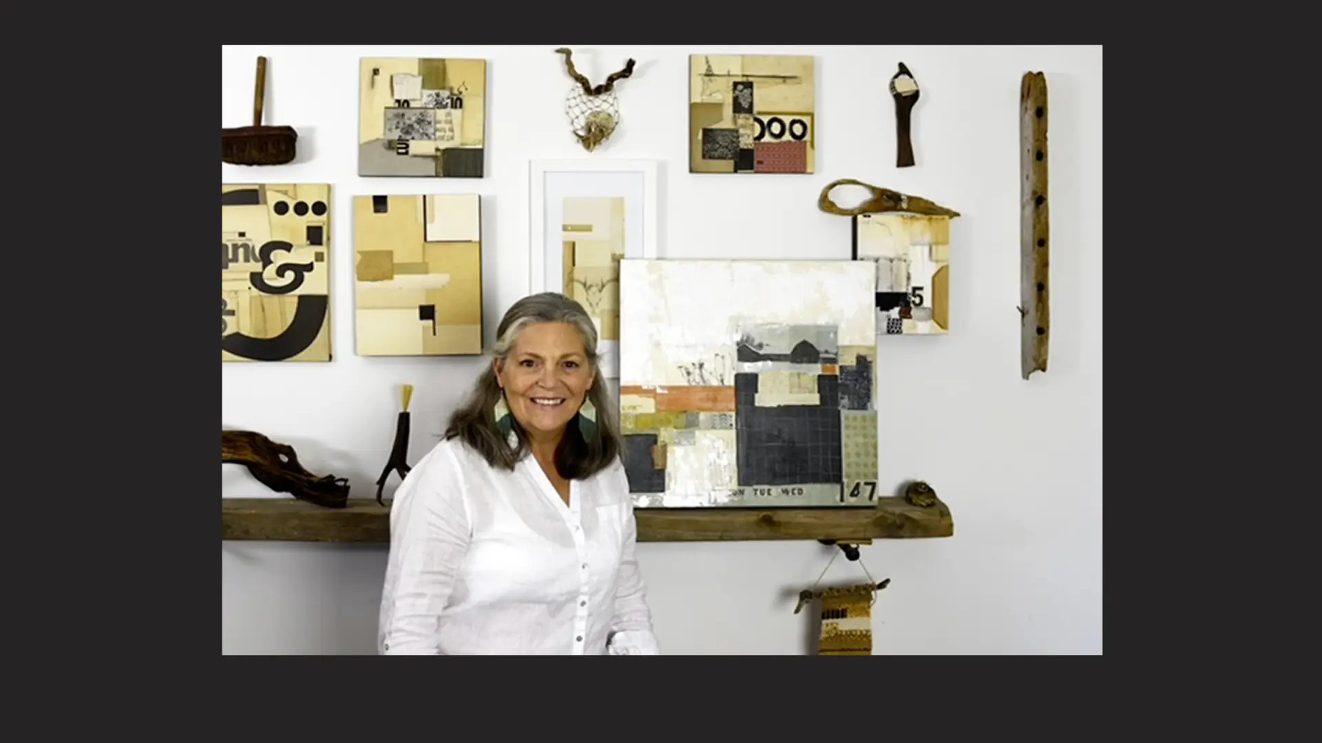 A woman stands with her collage artworks.