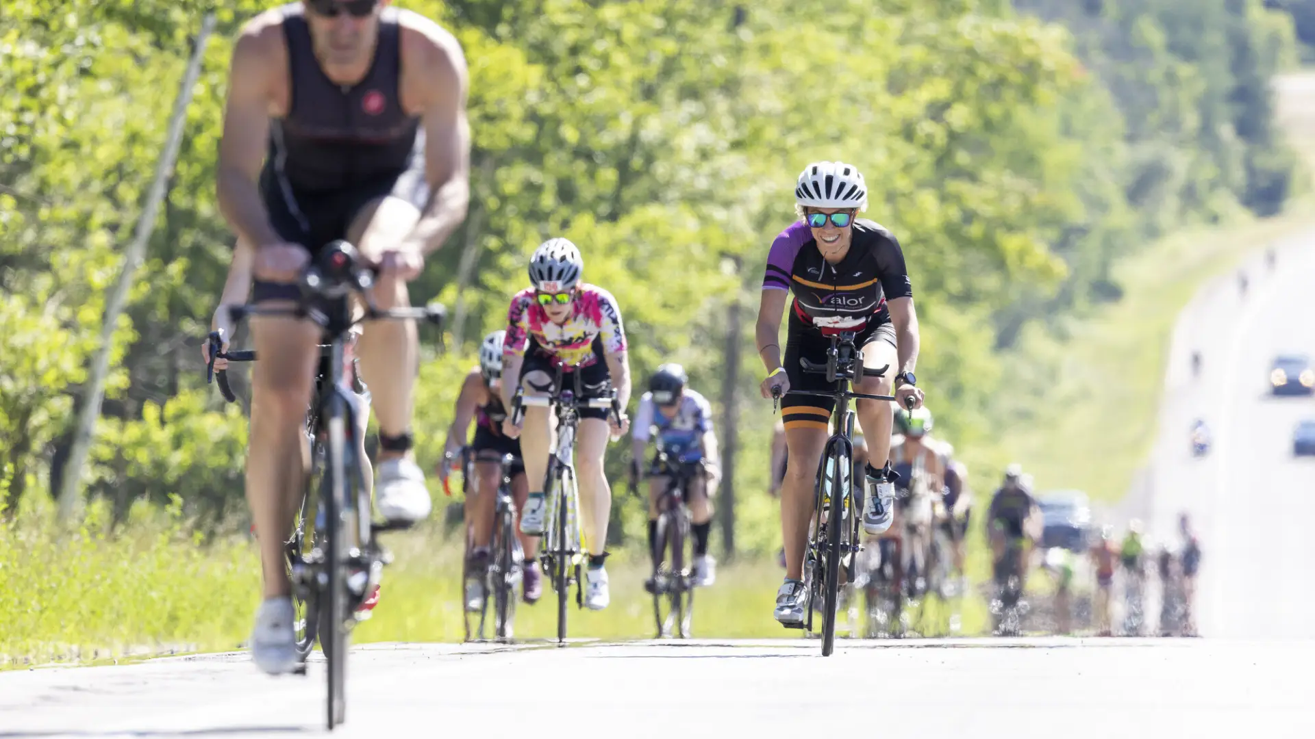 A large group of cyclists going up a road
