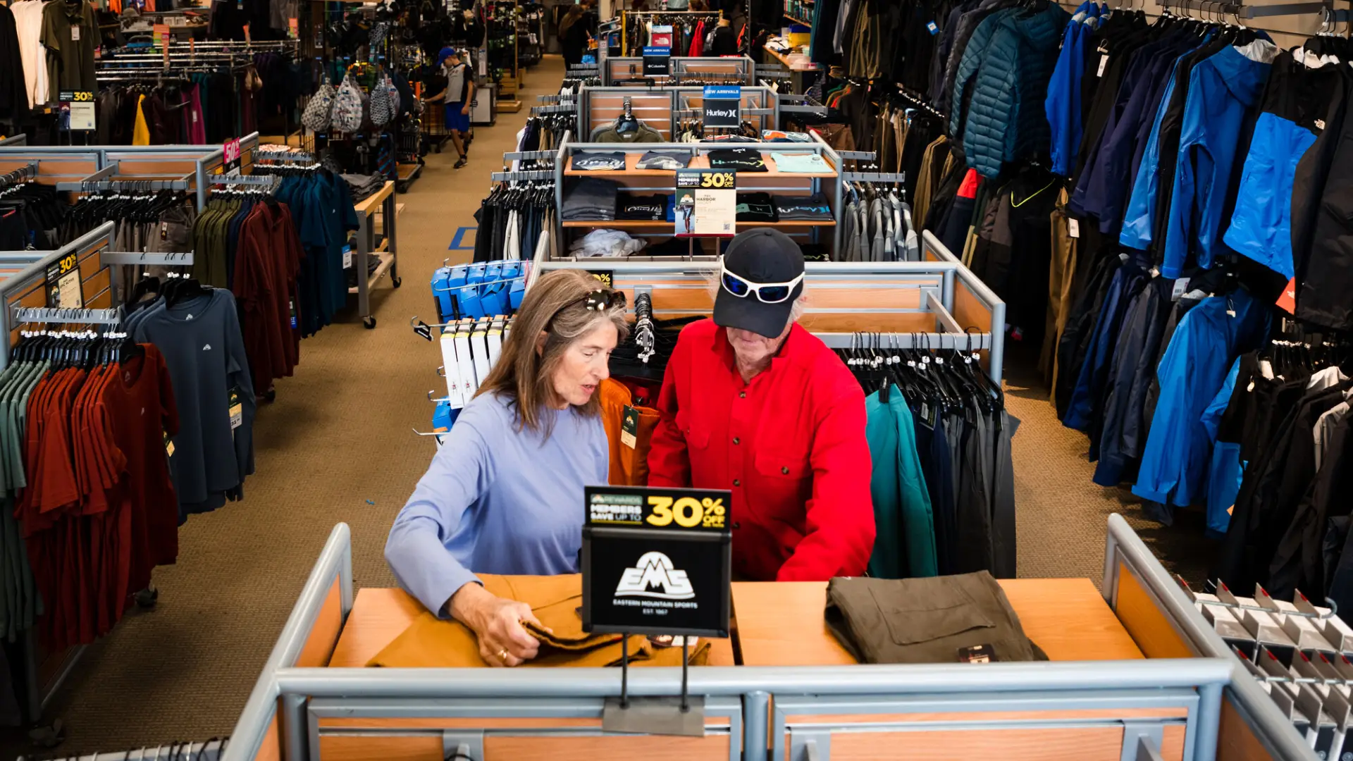 Two people standing at a front register of an outdoor clothing store in Lake Placid.