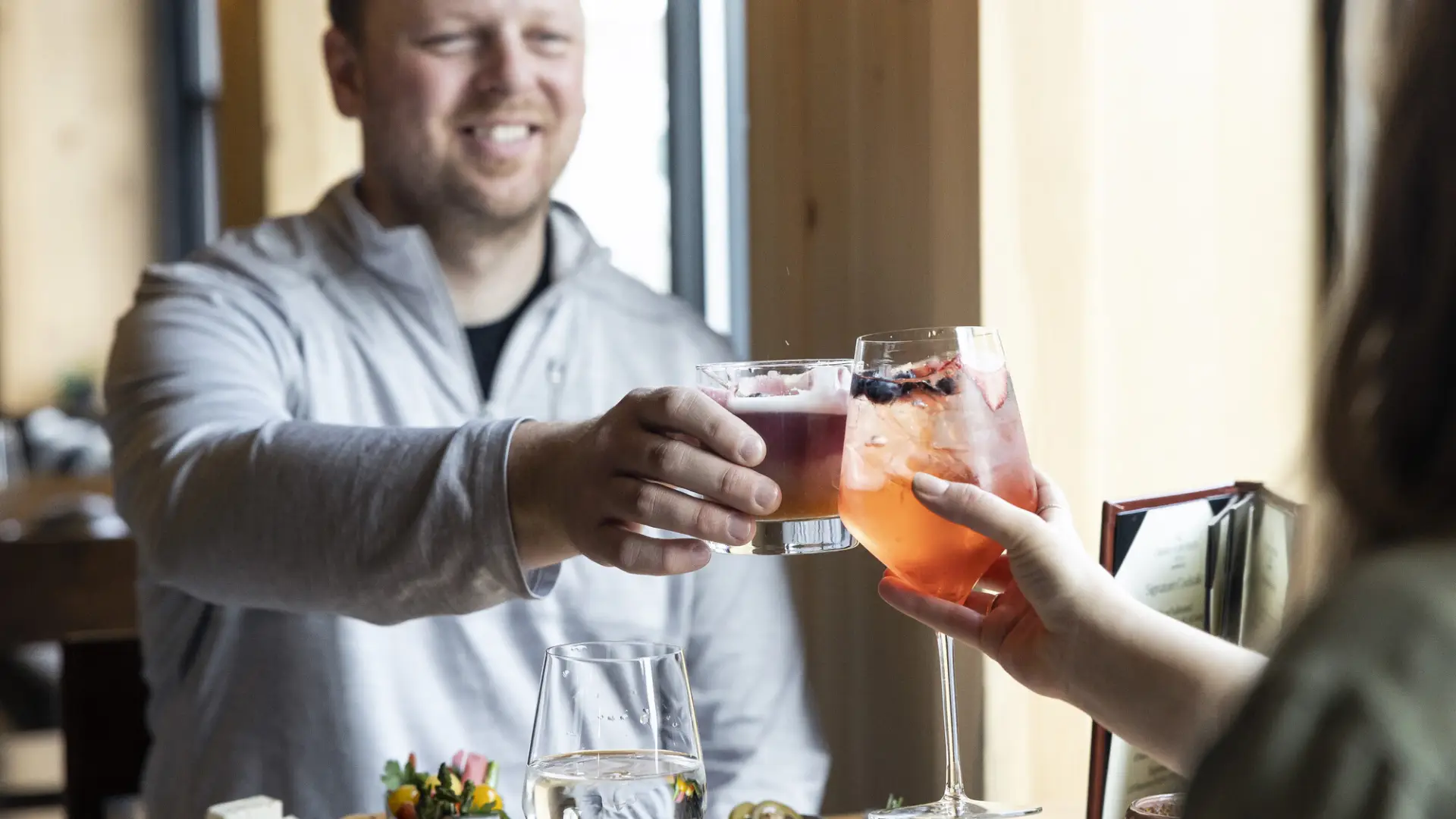 Couple clinking cocktails at dinner table