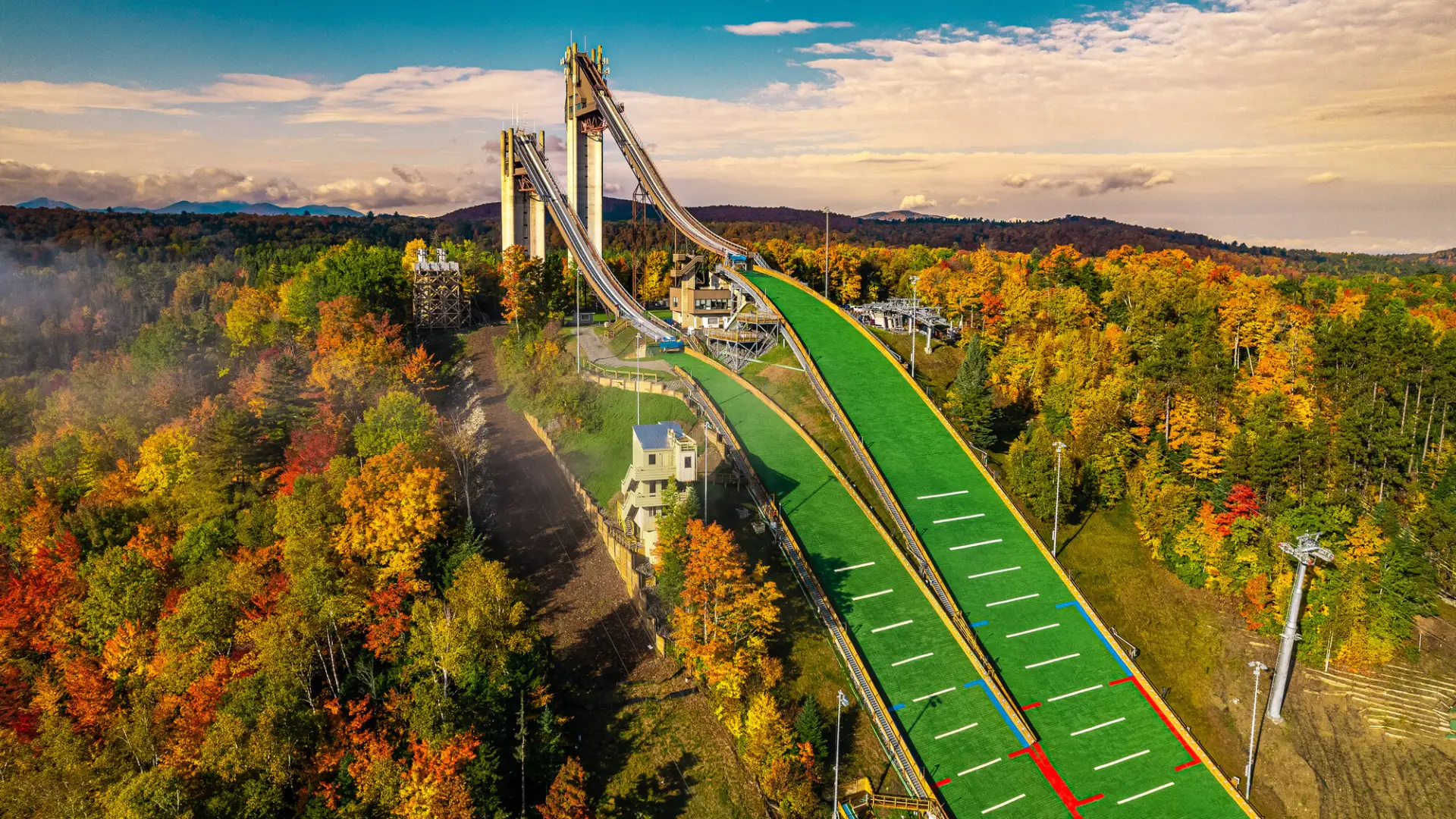 Drone aerial image of Lake Placid's 100 and 128-meter ski jumping towers and runs surrounded by fall foliage