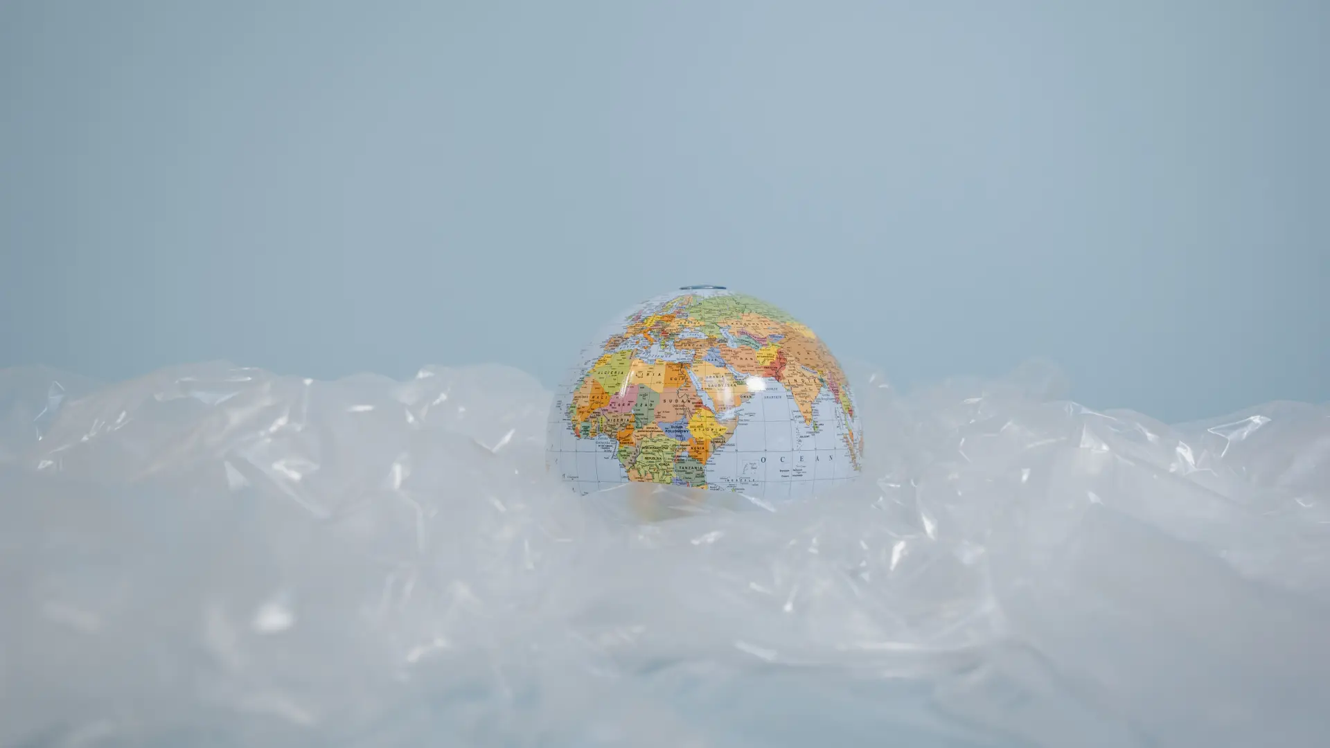 Stock image of small globe sitting atop scrunched plastic