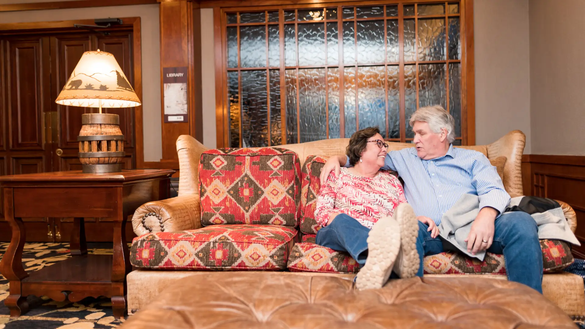 A couple relaxes on a couch in a luxury suite in one of Lake Placid's hotels