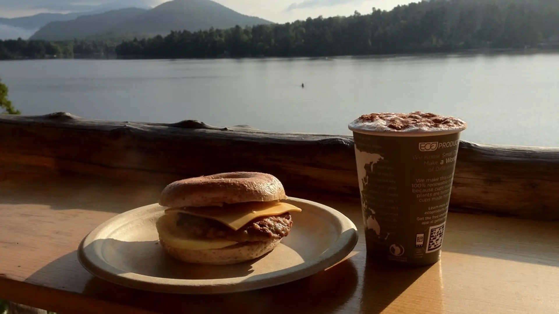 A breakfast sandwich and coffee overlook Mirror Lake.