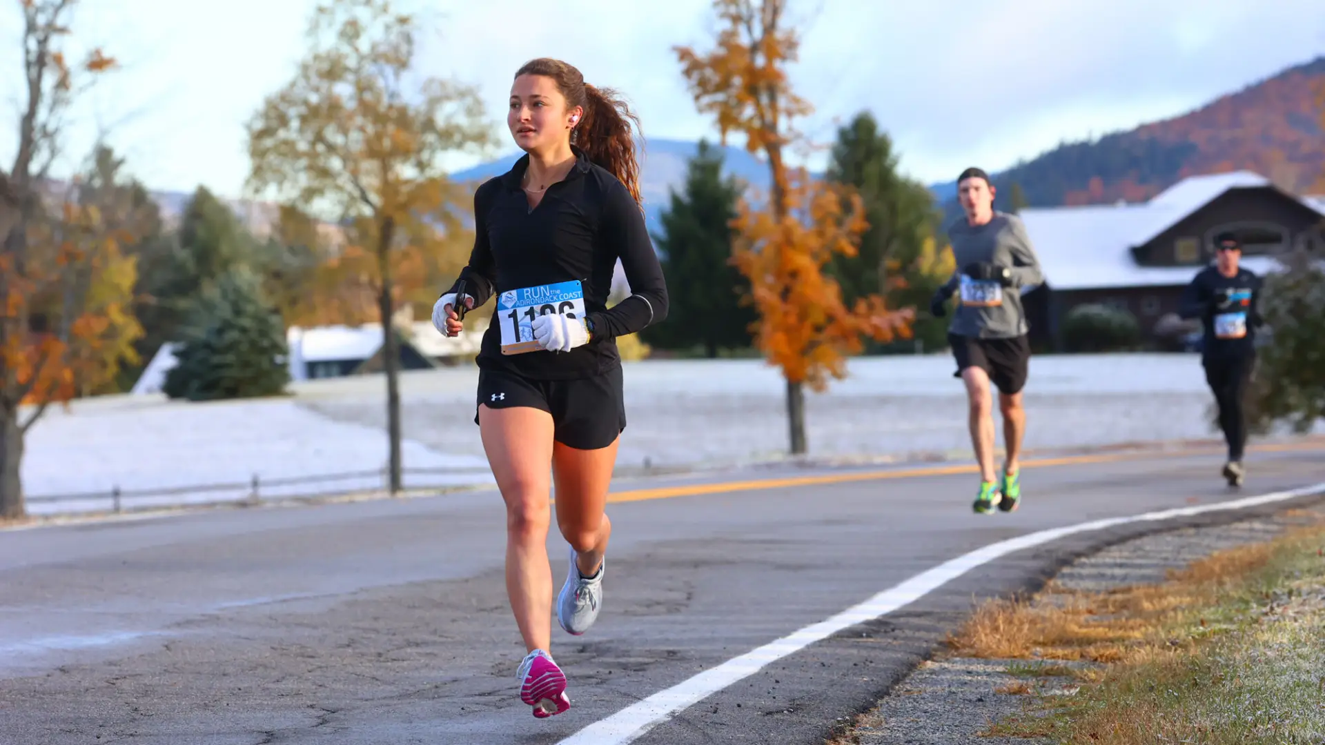 A woman runs in a fall race. 
