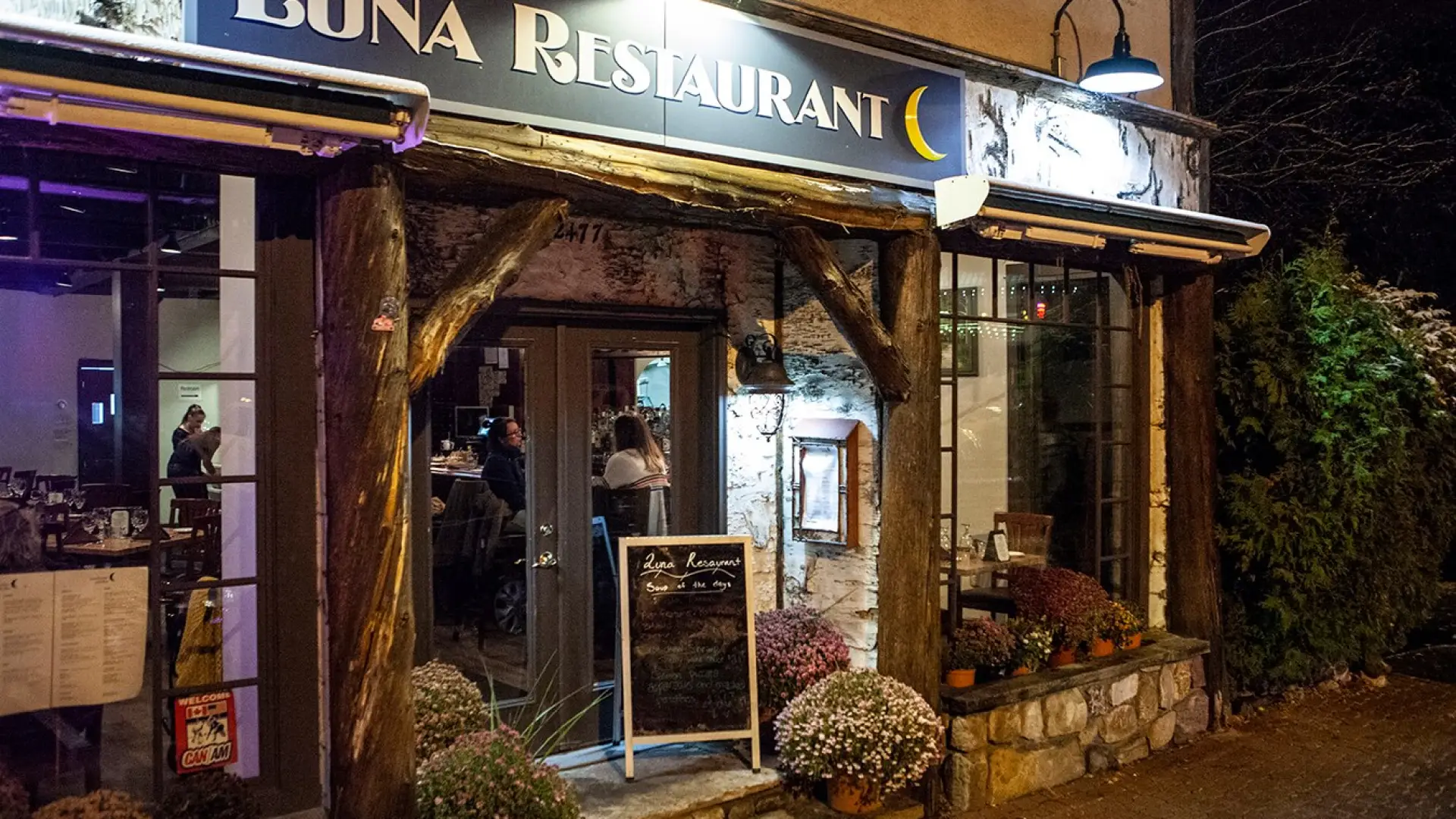 The exterior of a wood and birch bark trimmed restaurant. The sign reads Luna Restaurant.
