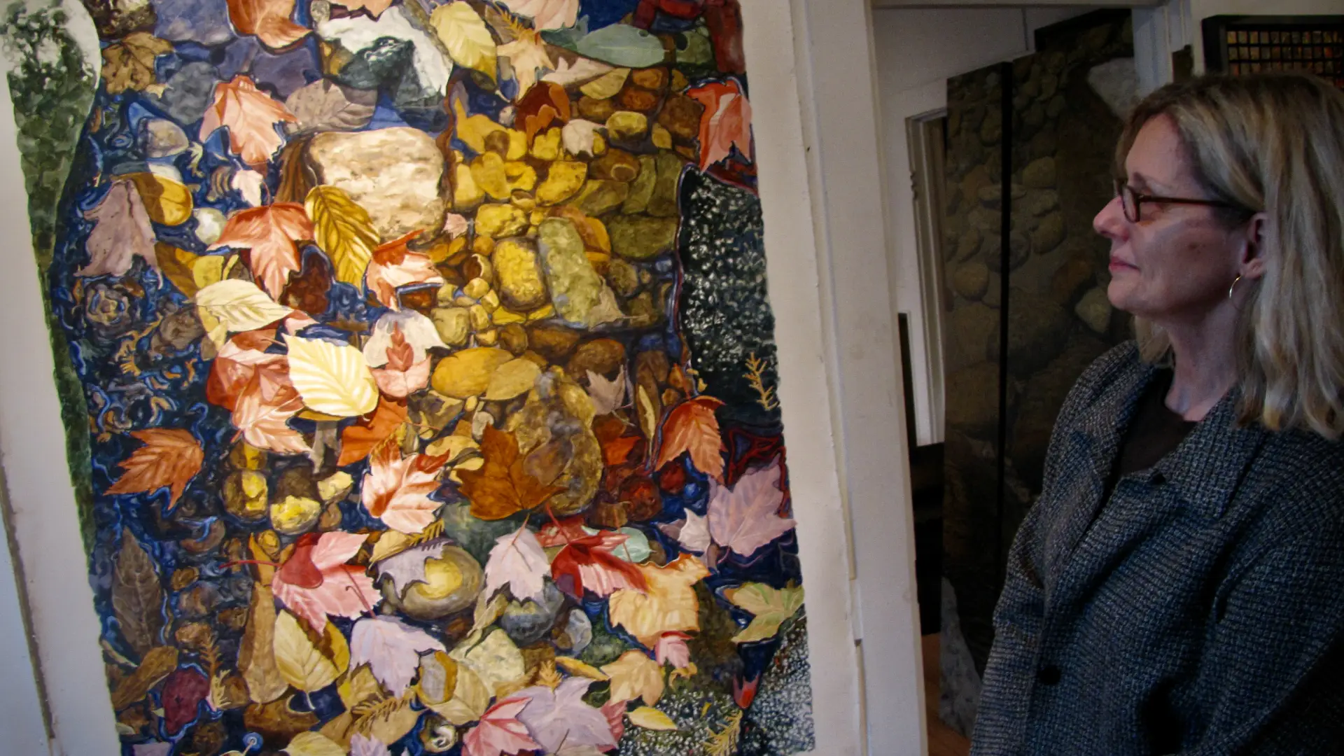 A woman looking at an art piece in a Lake Placid art gallery.