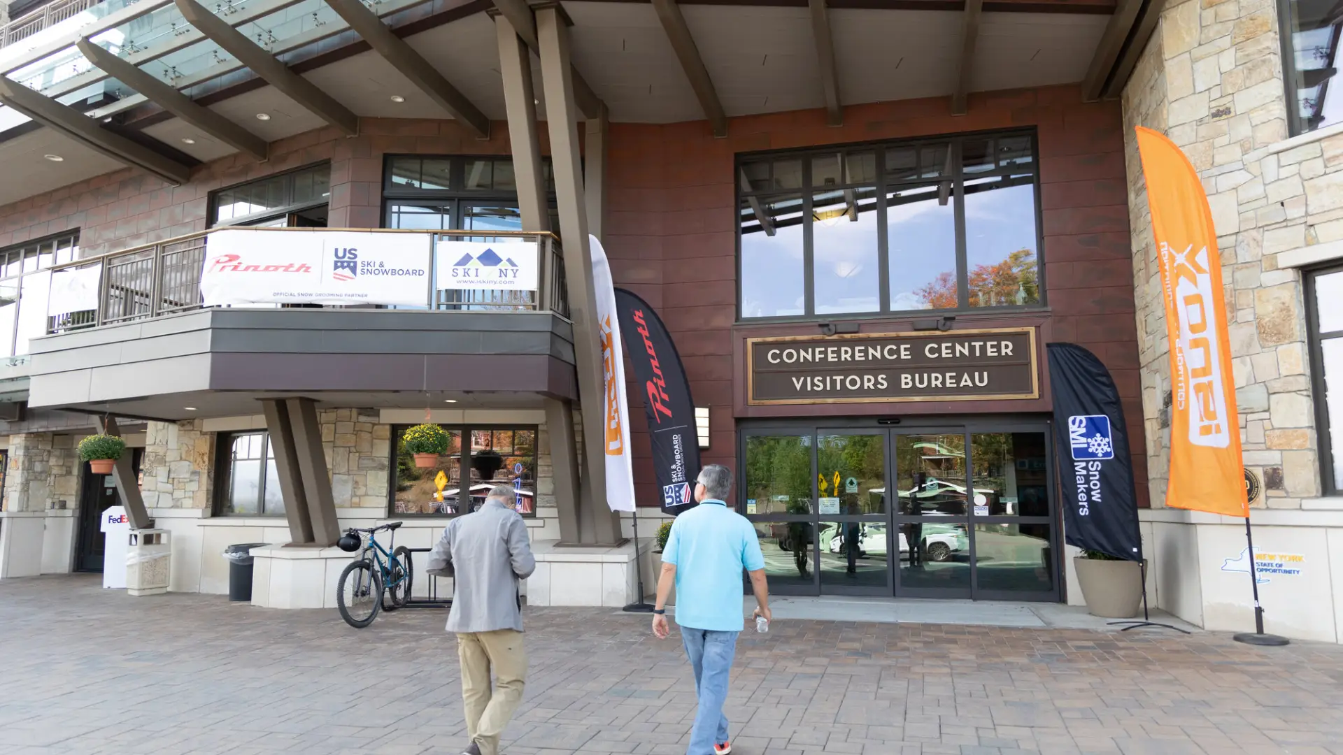 Two men walk into a conference center. 