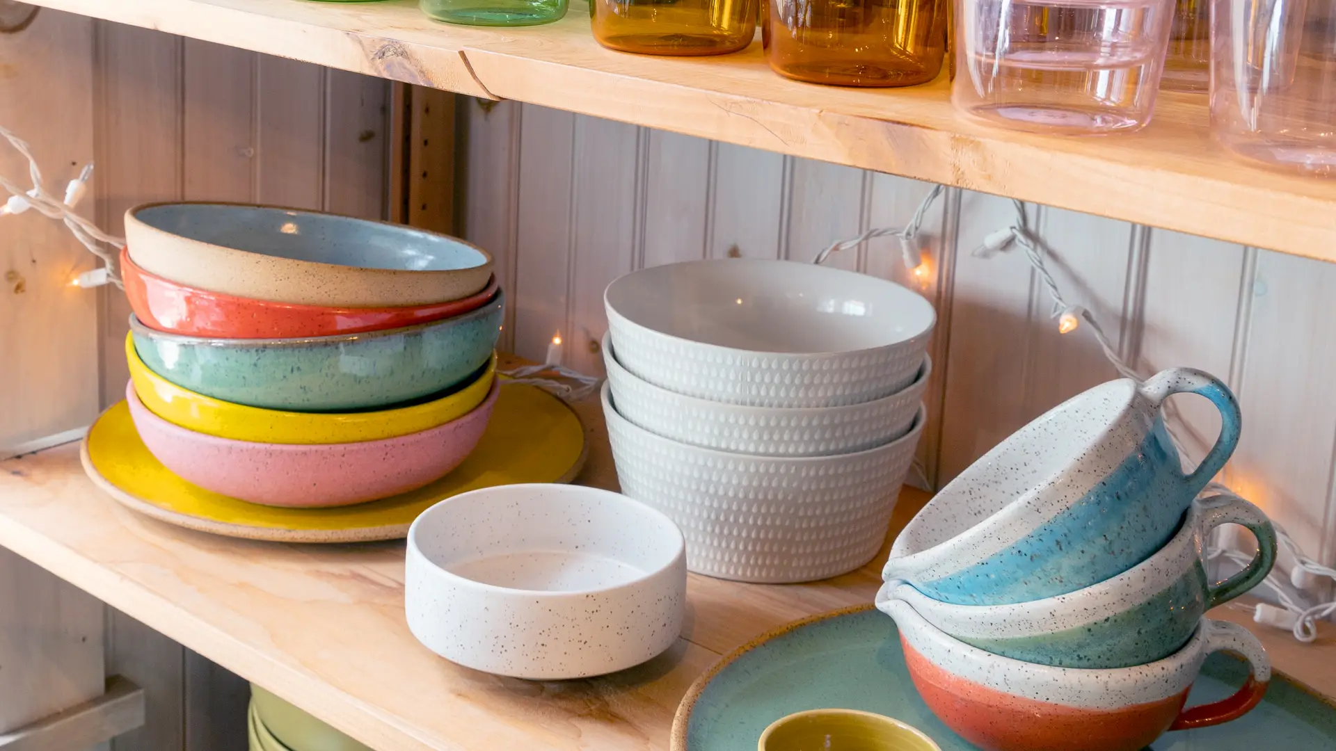 Kitchen decor with colorful glasses, bowls and cups.