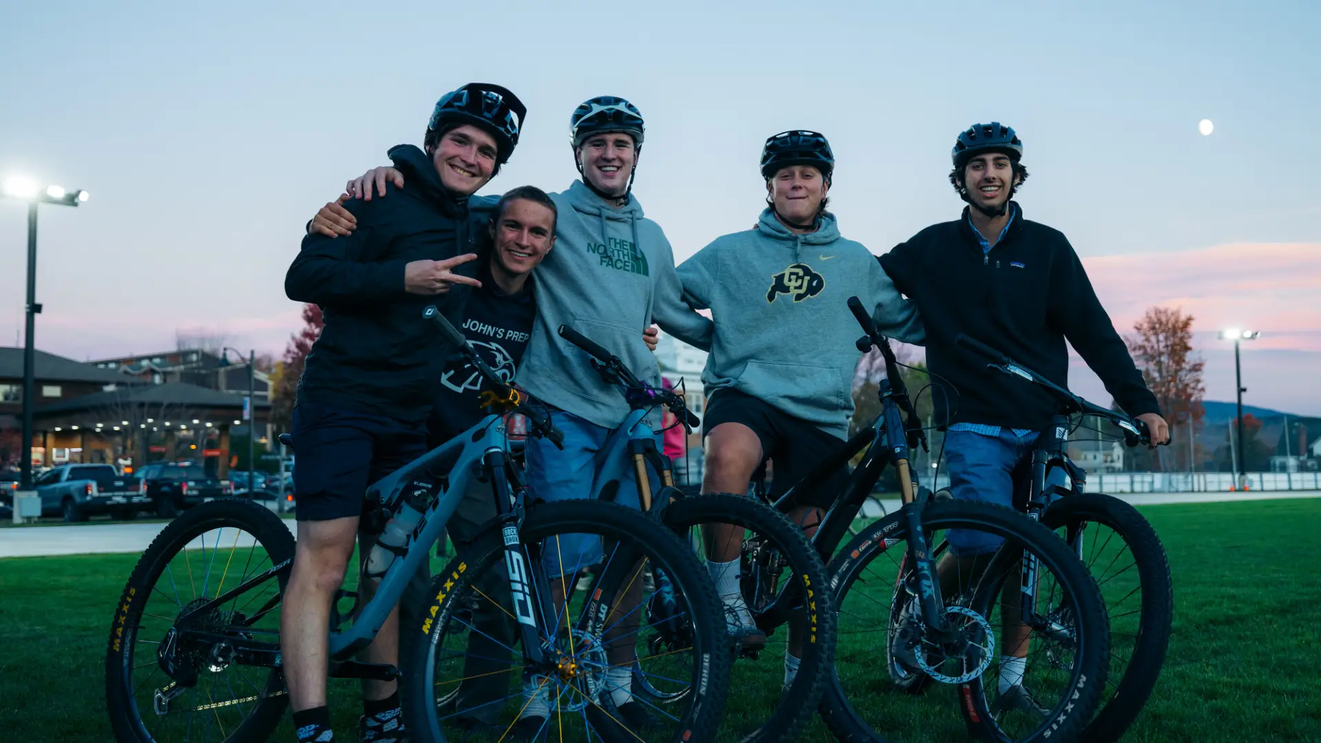 Group of five young men with bikes and helmets pose for group picture
