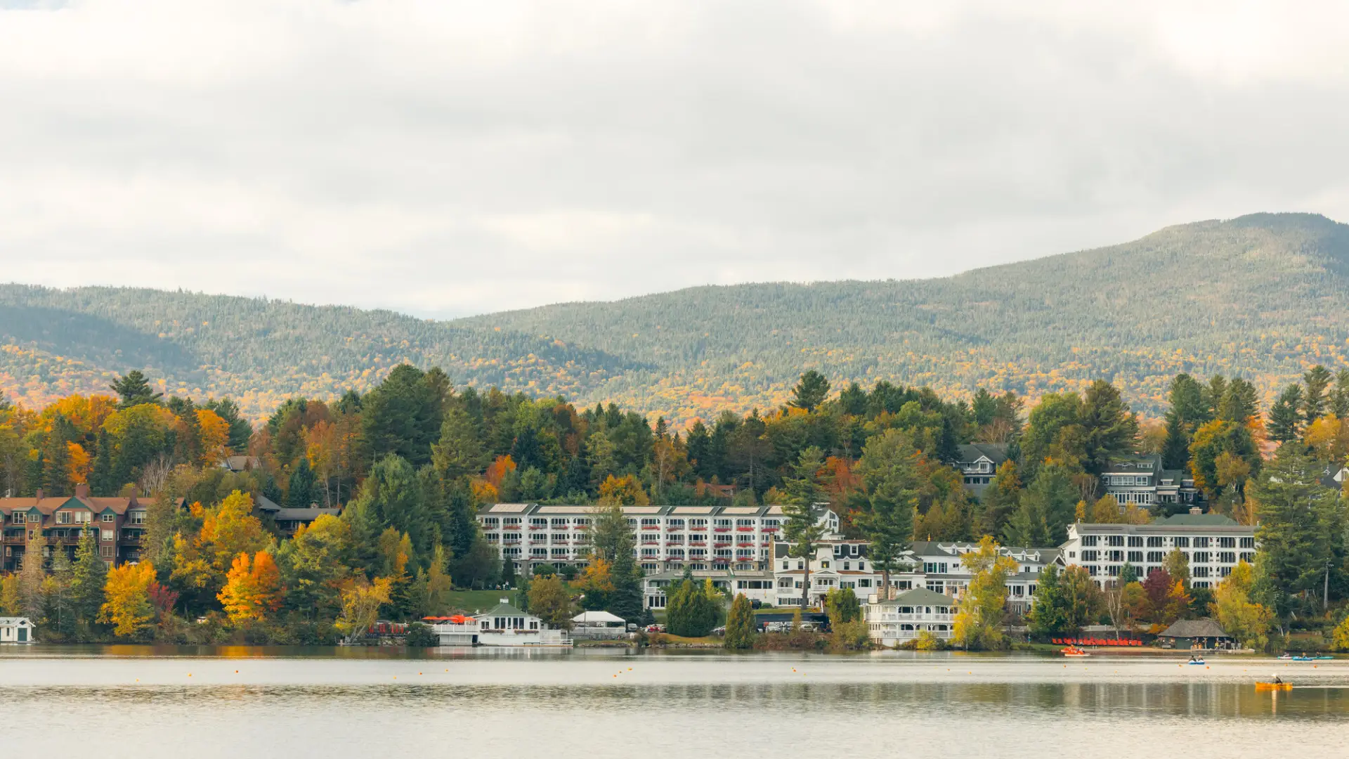 A white hotel on a lake in fall.