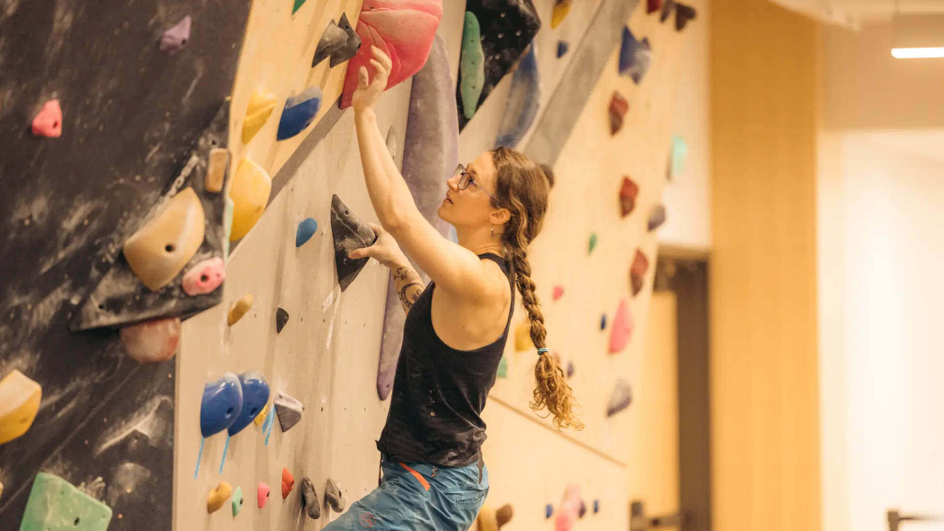 A woman climbing at an indoor climbing gym.