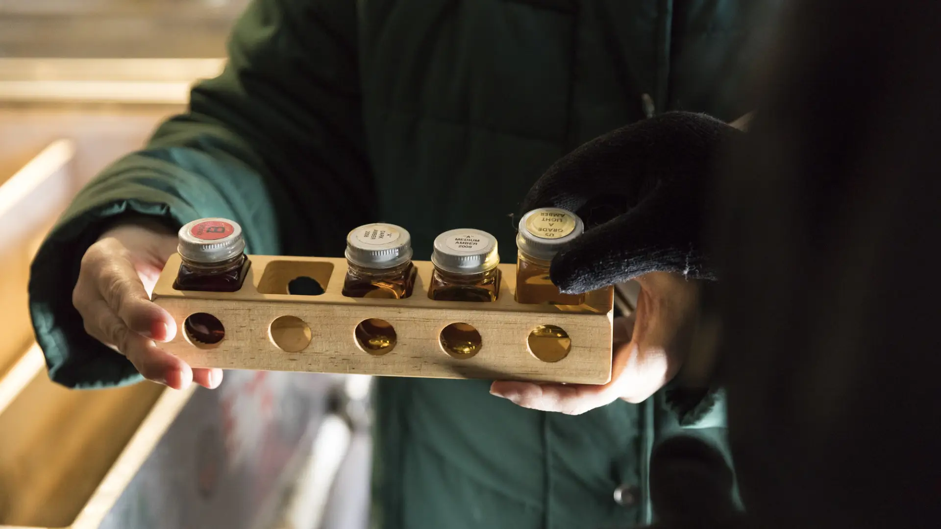 Jars of maple syrup of varying grades.