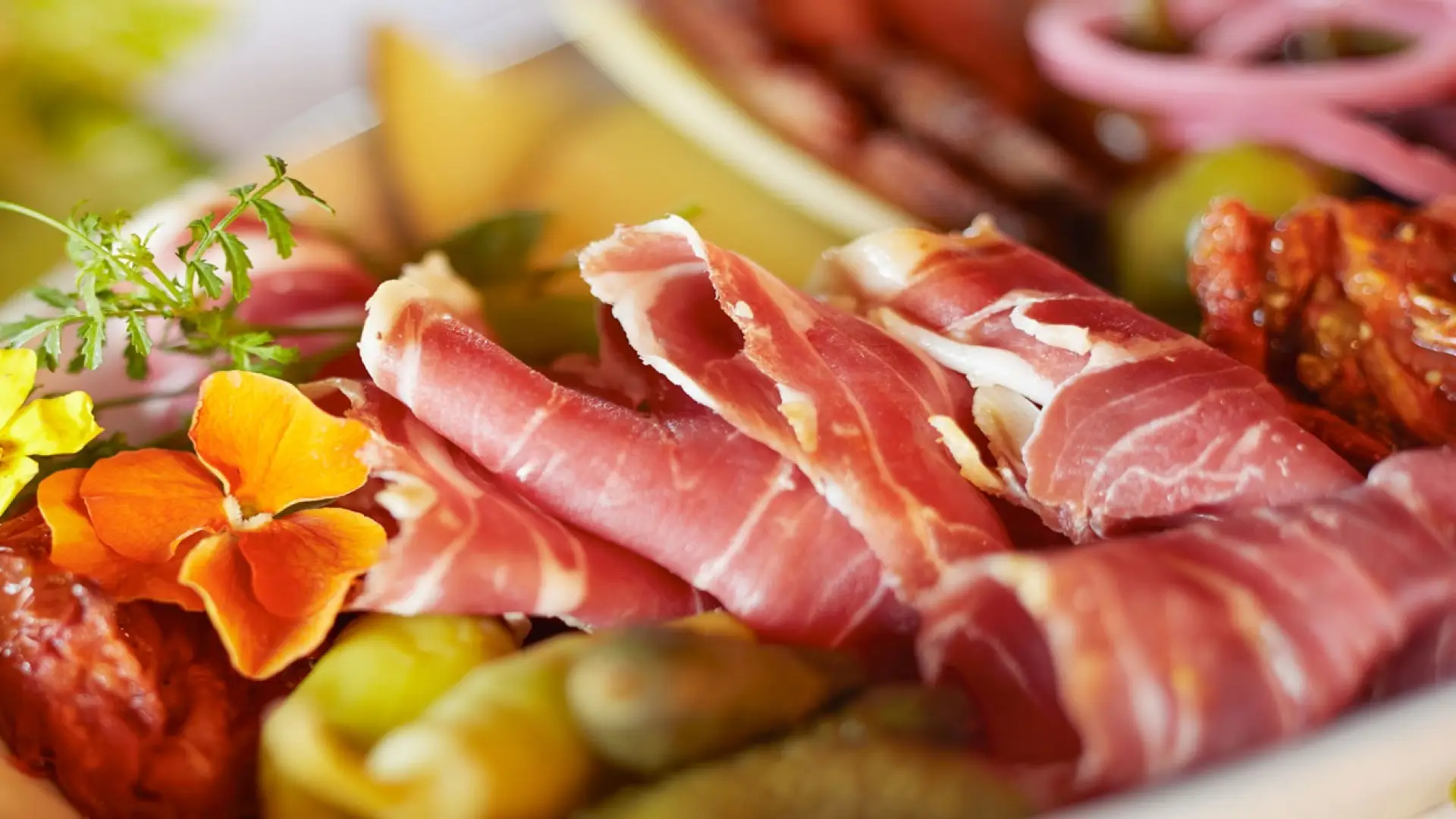 Delectable meats and cheeses on a plate.