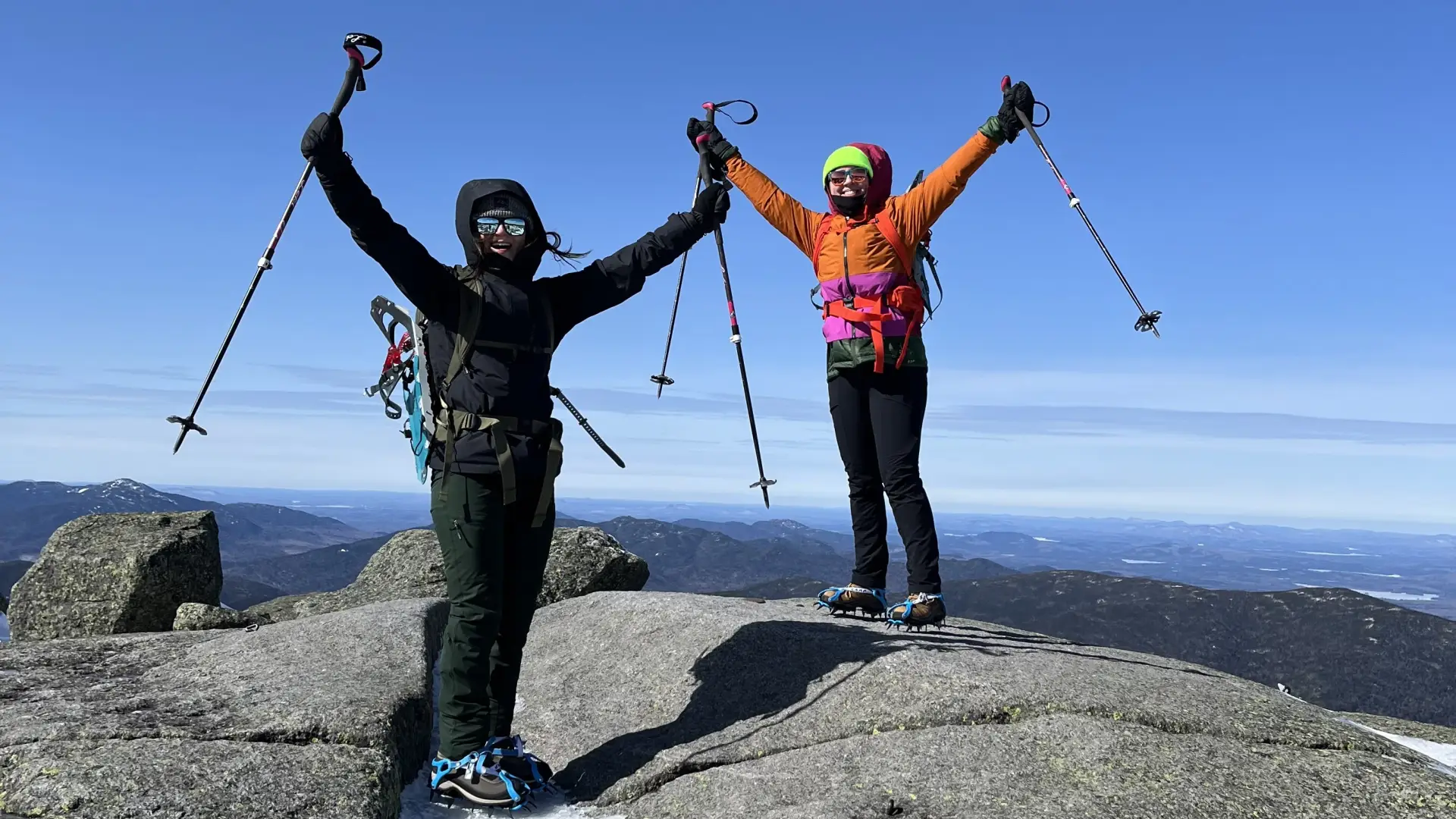 Mountaineers throw their hands in the air in celebration after ascent