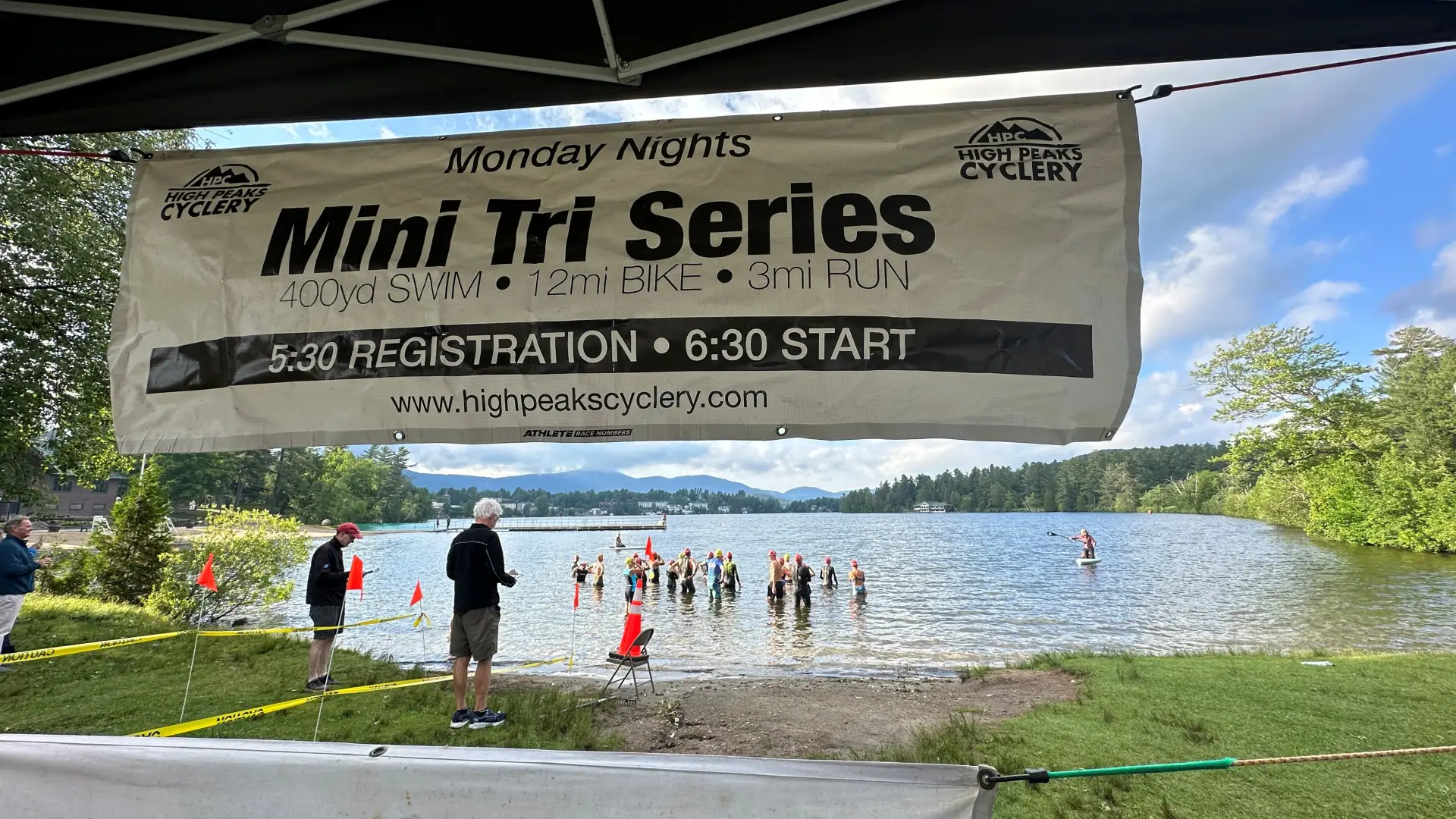 View of mini tri swim start from under pop-up tent with back of banner along top of frame