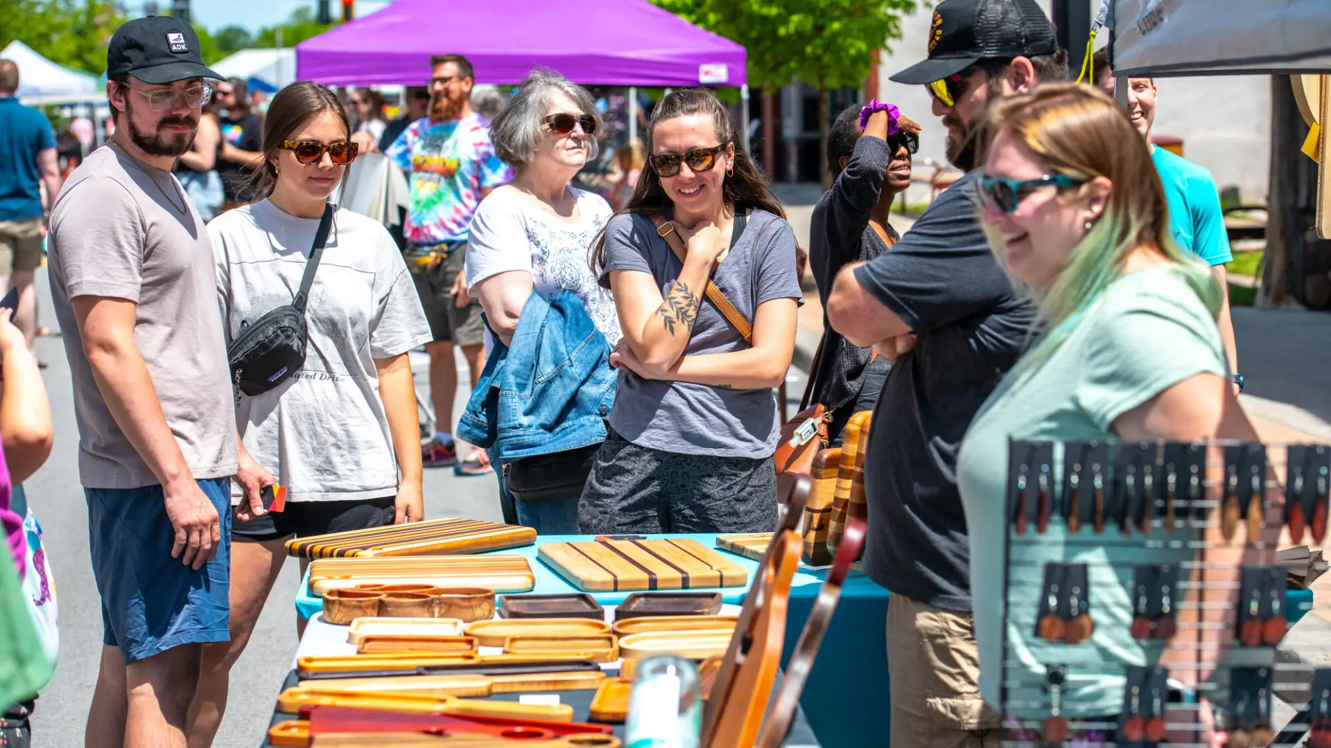 A crowd of people enjoying an event during a sunny day.