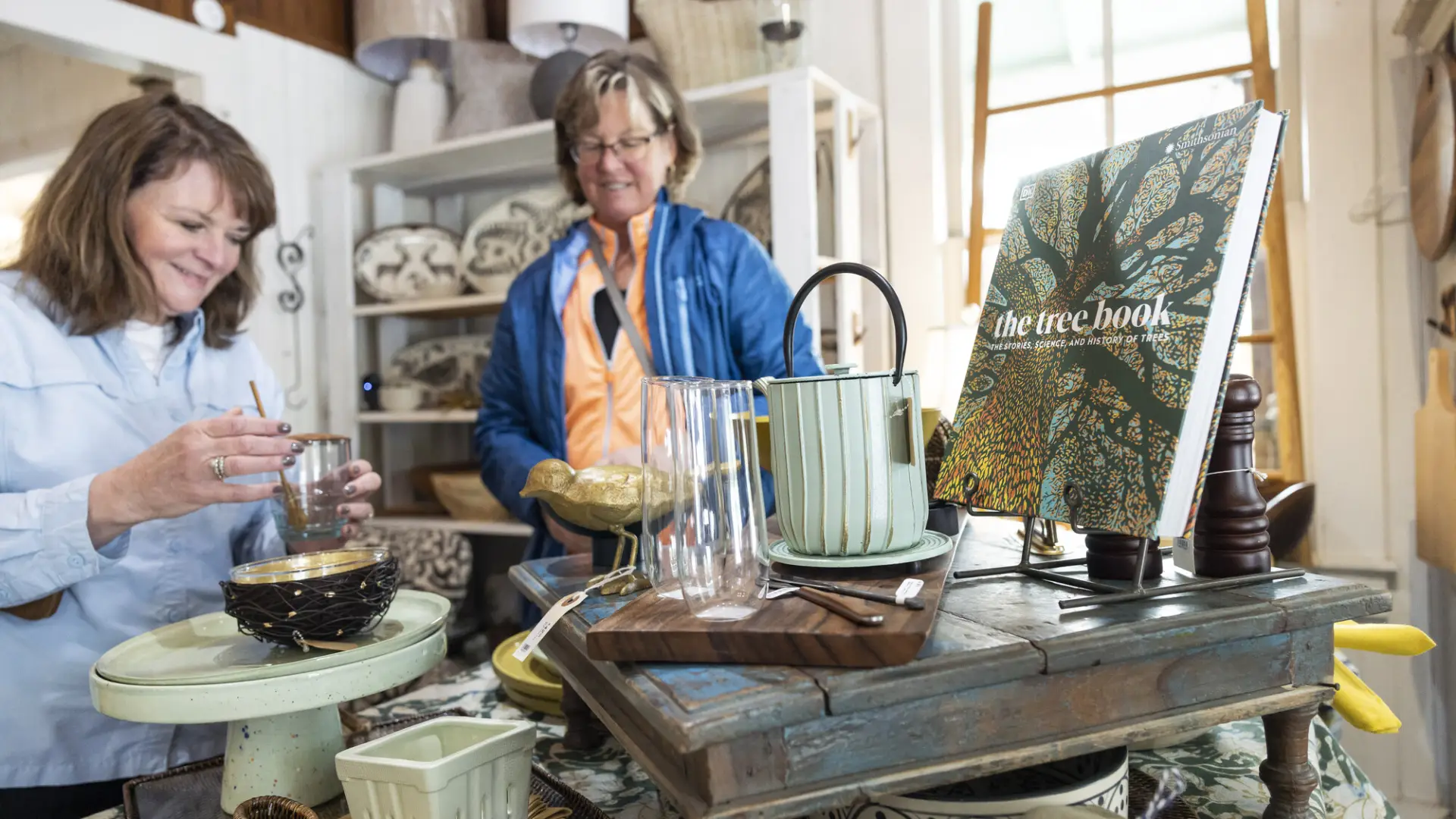 Women look through the stacks of treasures to find books, and decor pieces to bring home