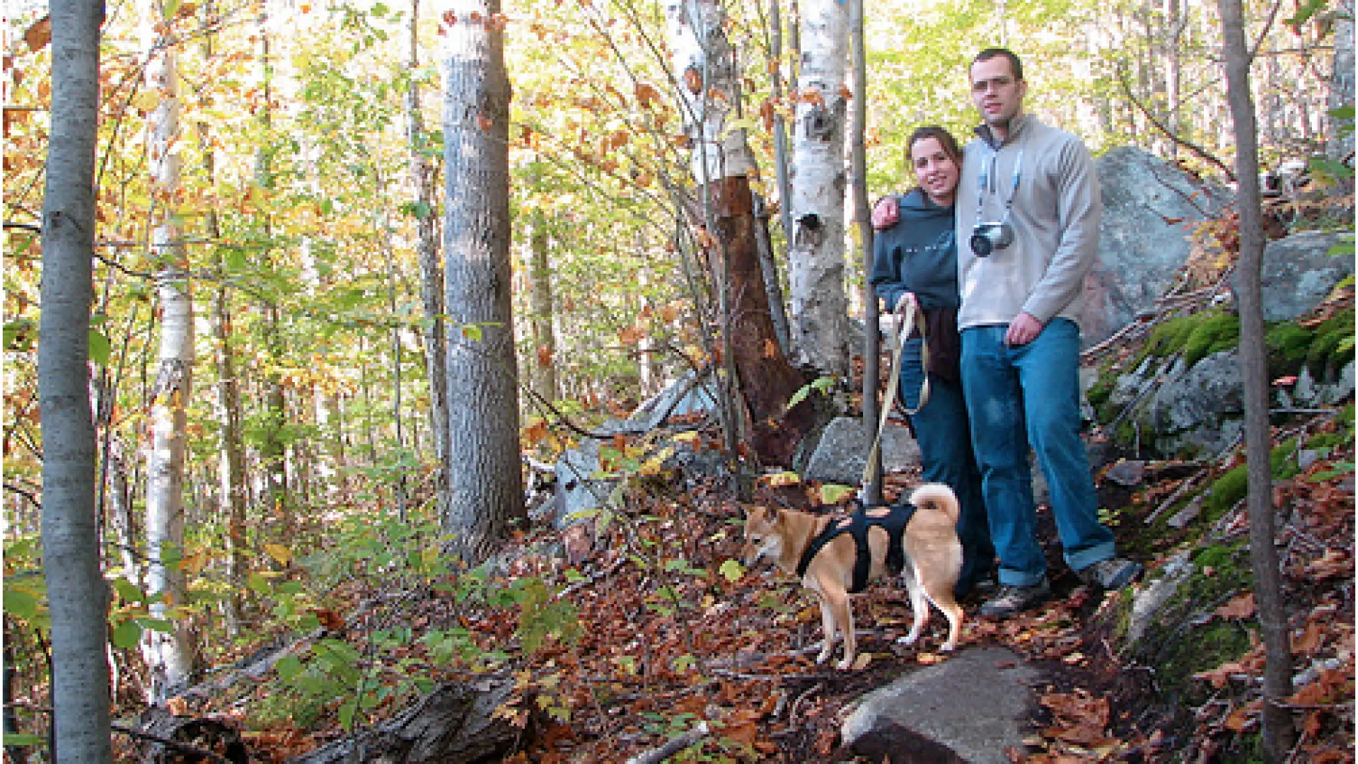 Couple hiking in woods with dog, Lake Placid, NY