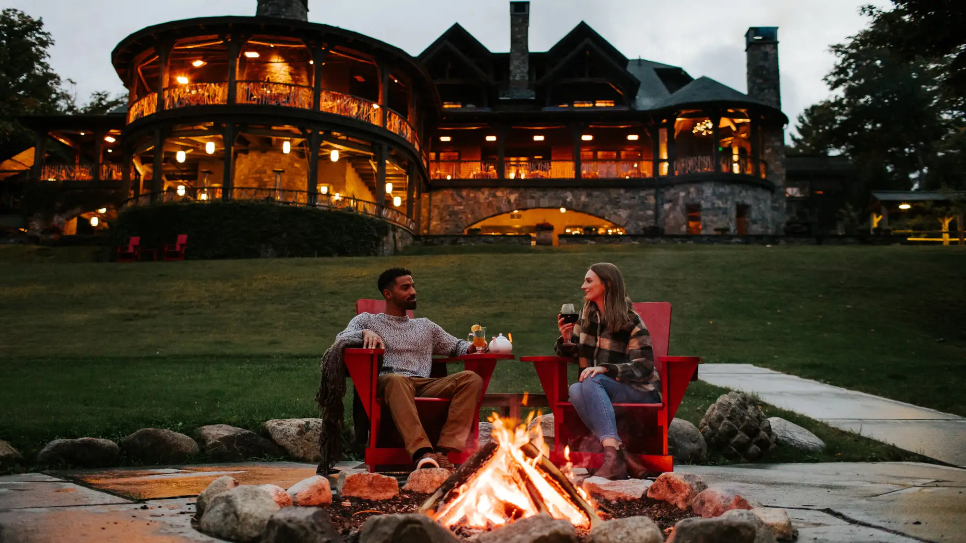 A man and woman share drinks at a resort. 