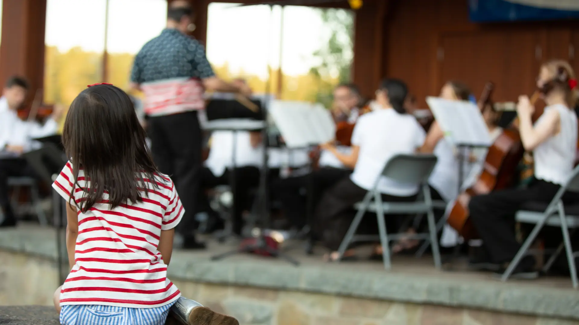 Child watches a band play in the bandshell