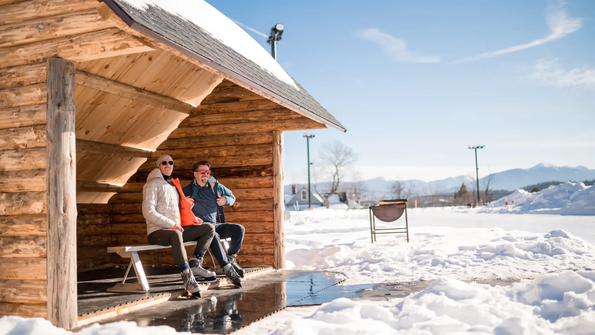 A couple laces up their skates in a lean-to at the Oval