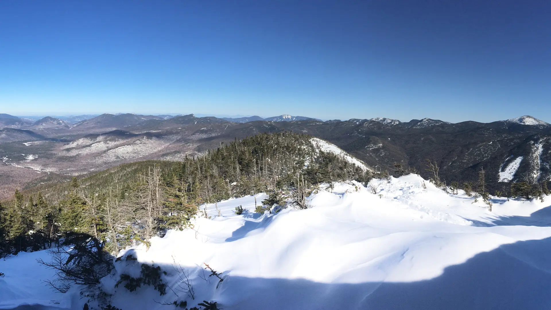 The view of mountains from a snow summit