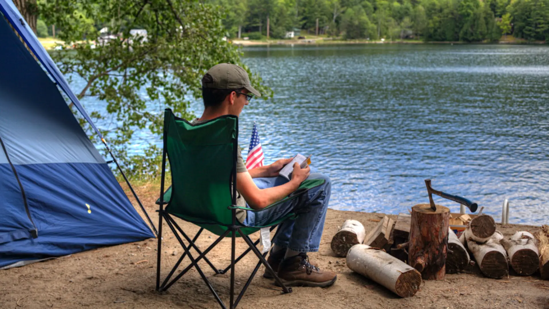A person sitting in a camp chair by the water.