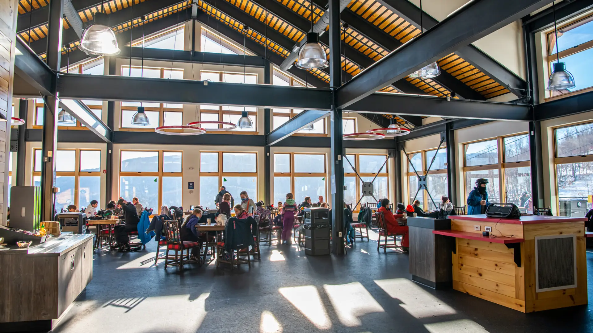 A large, open and airy dining room in the new lodge with lots of windows and happy diners.