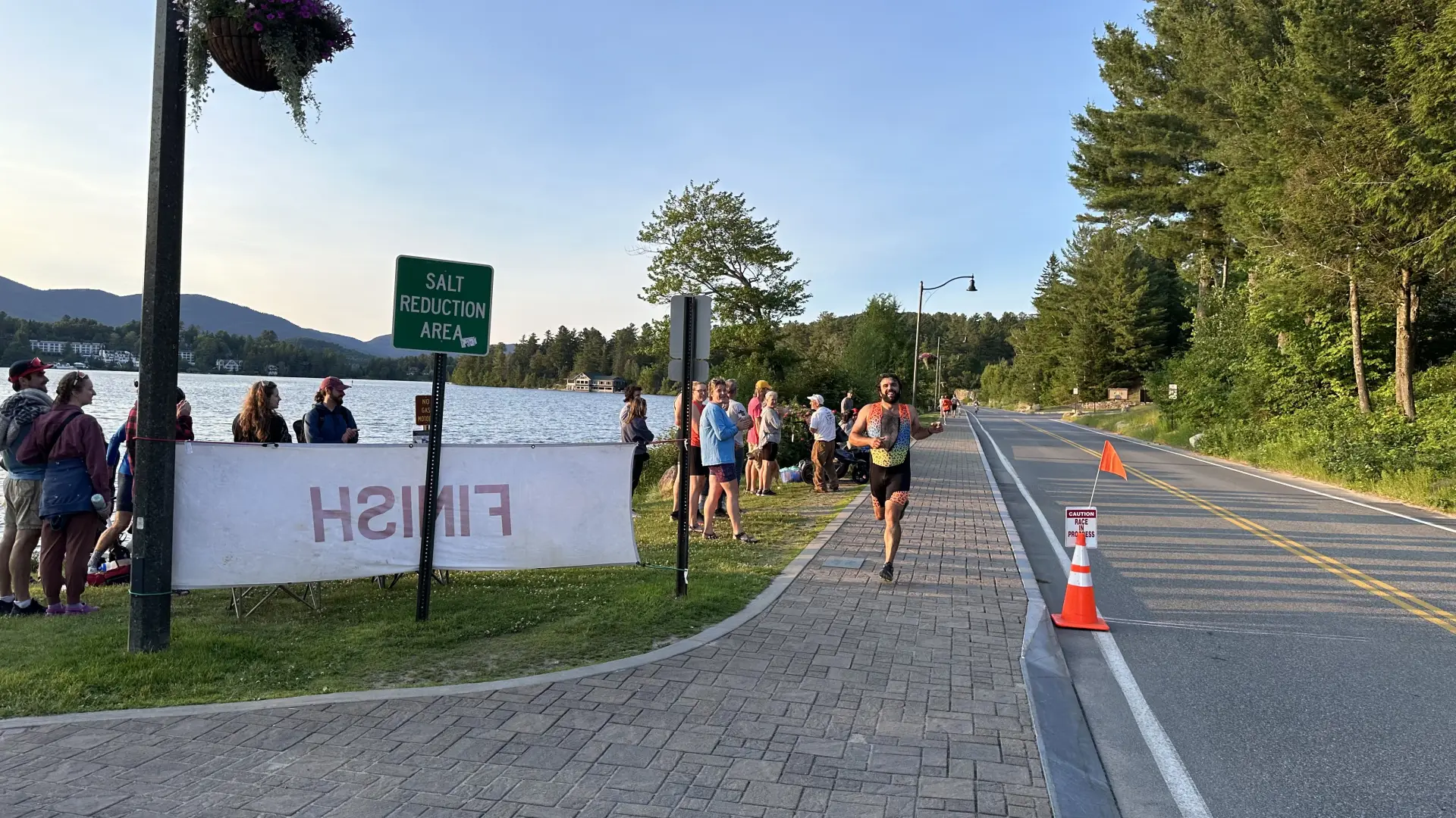 Runner approaches on sidewalk past Finish sign