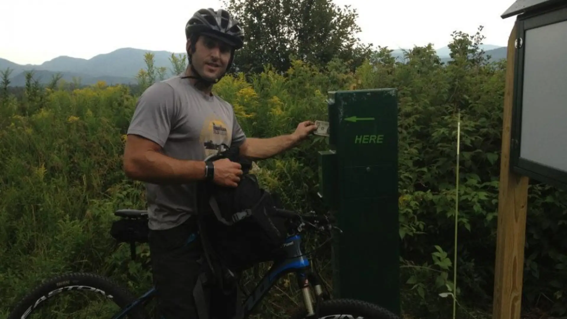 A rider making a donation in the box on the Lake Placid Club and Resort property