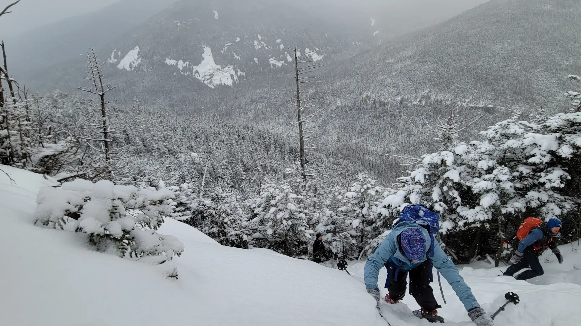 Hikers going up a snow covered cliff