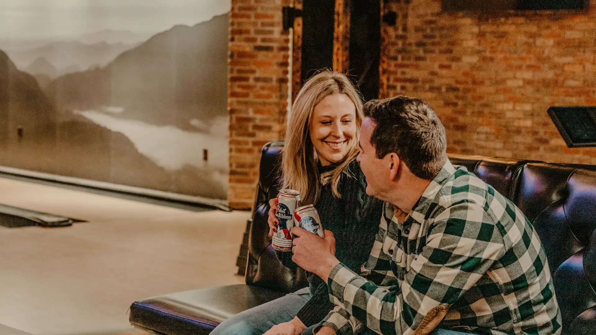 A happy couple enjoy a beverage by the bowling lanes.  Photo Credit to A. Kelly.