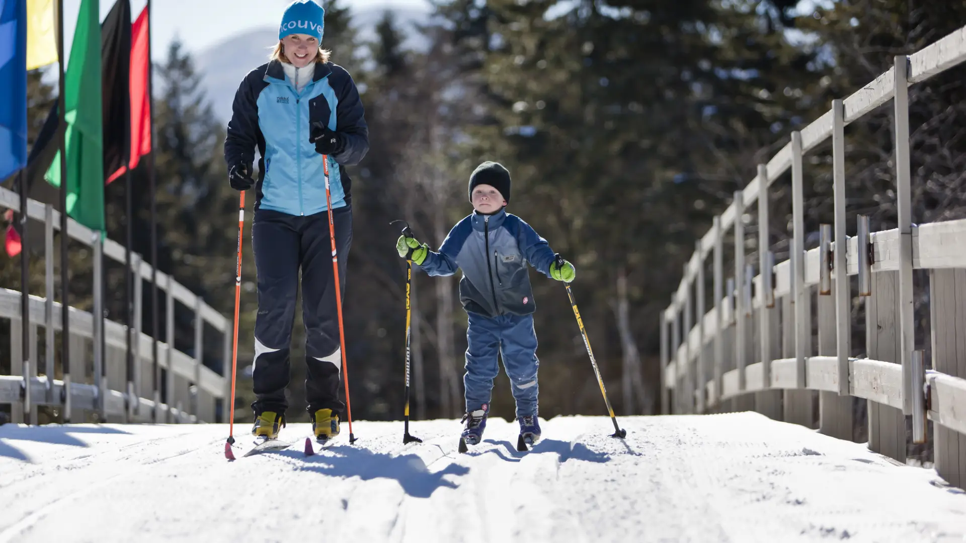 Mother and son cross country ski across bridge